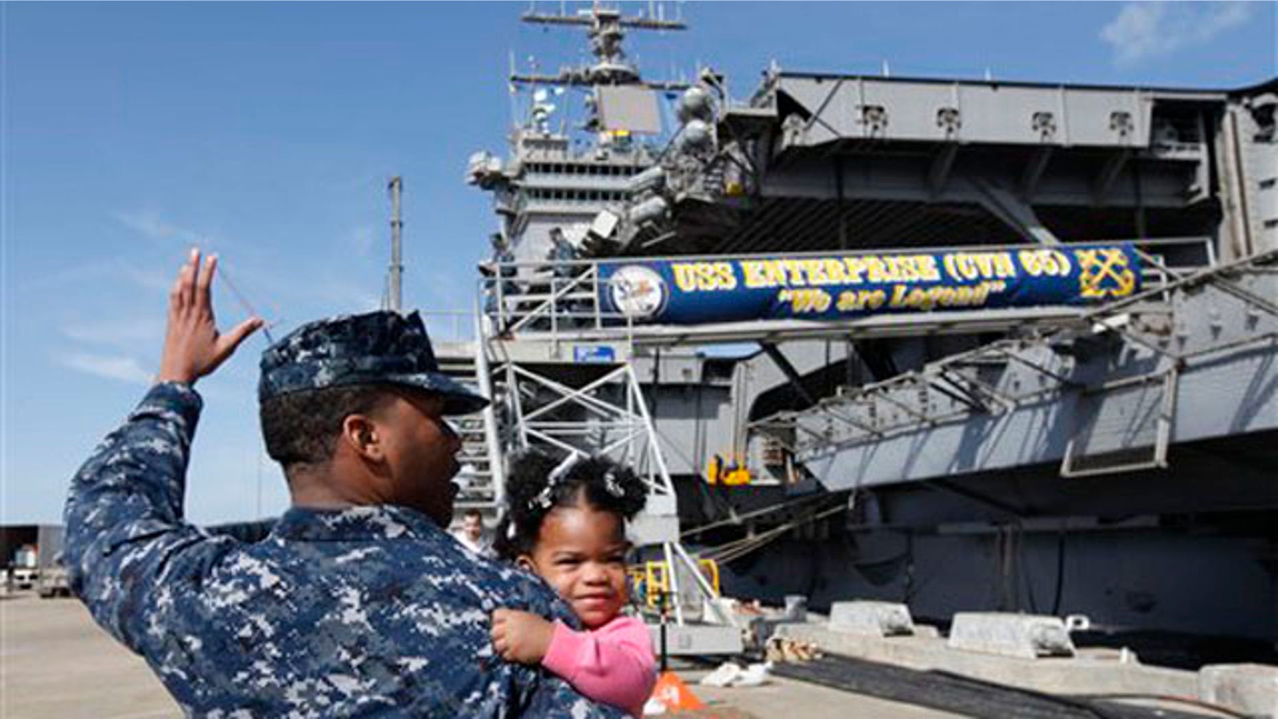 March 8, 2012: In this photo, Petty Officer 3rd Class Michael Joseph, carries his daughter Maleah, 1, to his re-enlistment ceremony aboard the nuclear powered aircraft carrier USS Enterprise at the Norfolk Naval Station in Norfolk, Va.