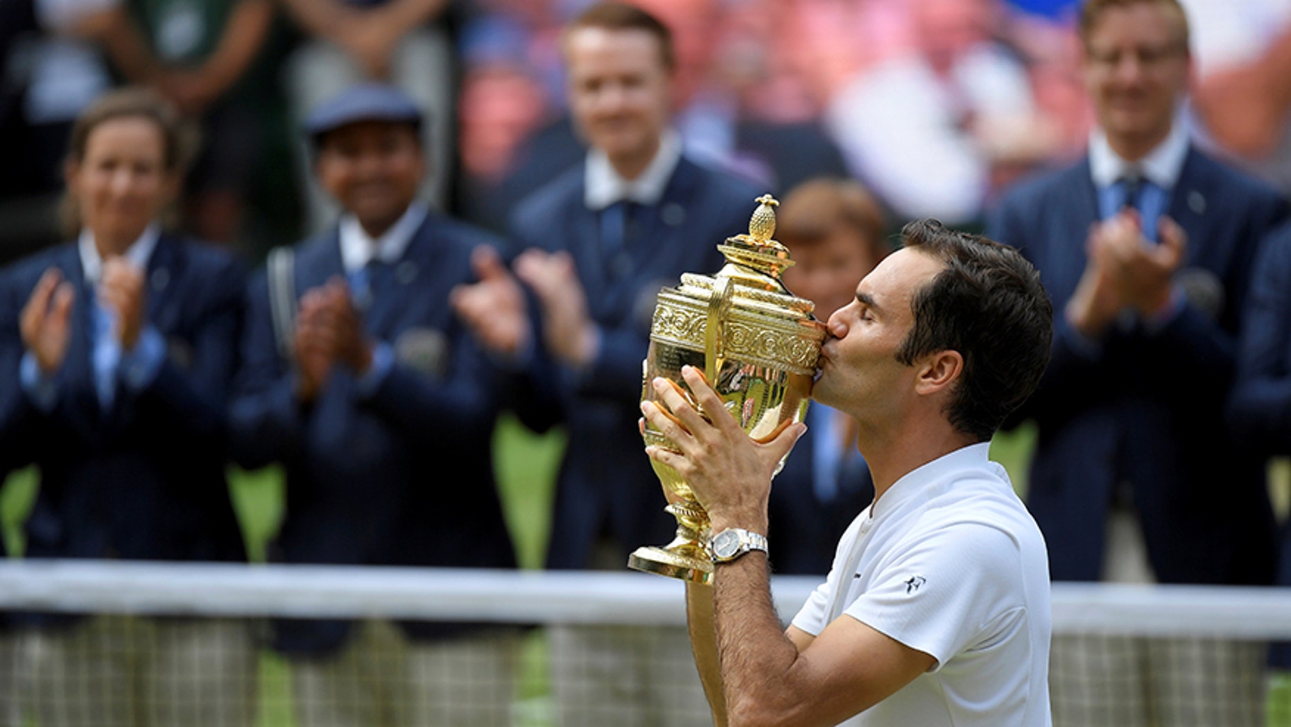 Switzerland’s Roger Federer celebrates with the trophy after winning the Wimbledon final against Croatia’s Marin Cilic in London, July 16, 2017.