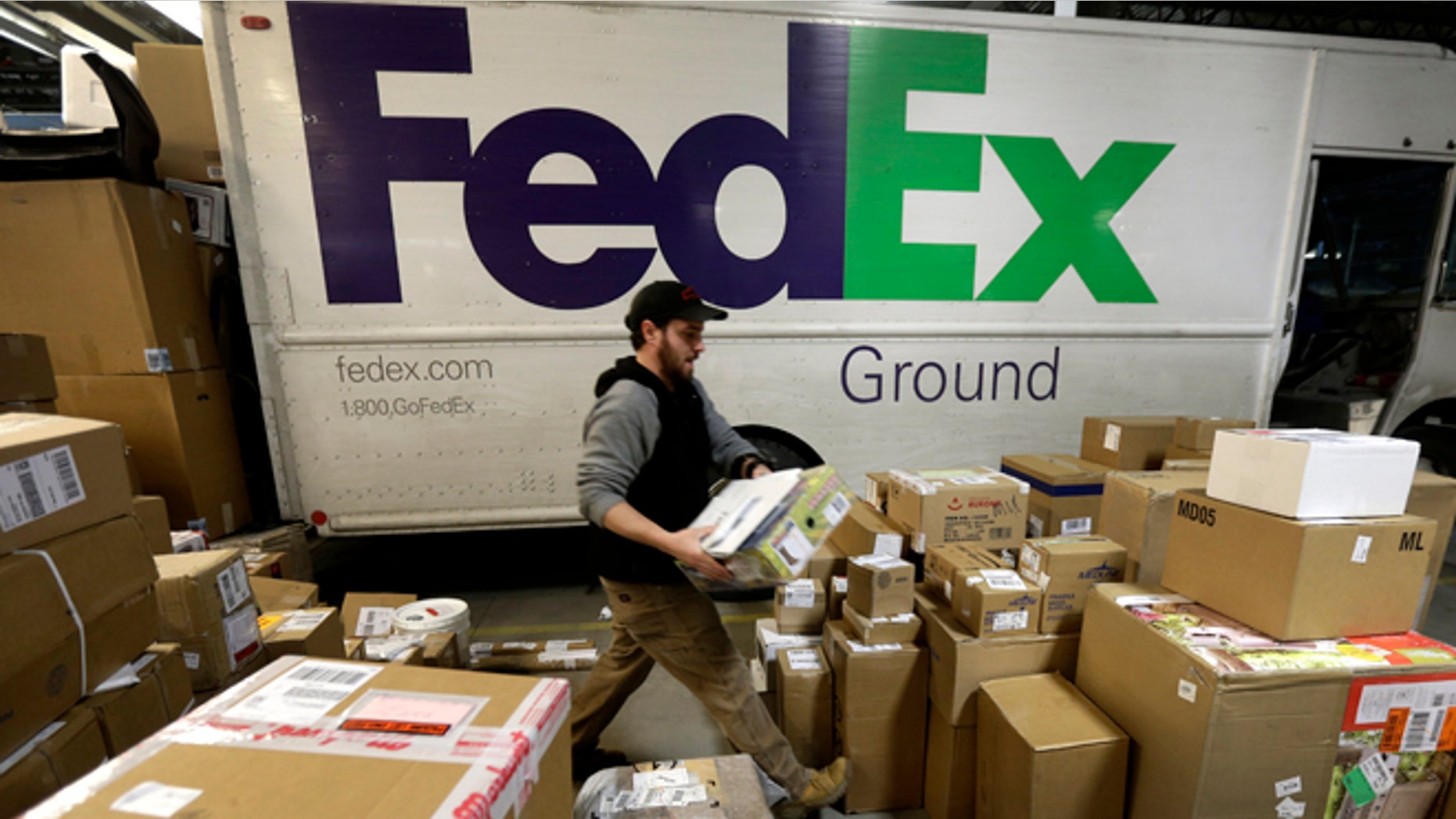 Dec. 16, 2013: In this file photo, package handler Chris Addison arranges packages before loading a delivery truck at a FedEx sorting facility in Kansas City, Mo.