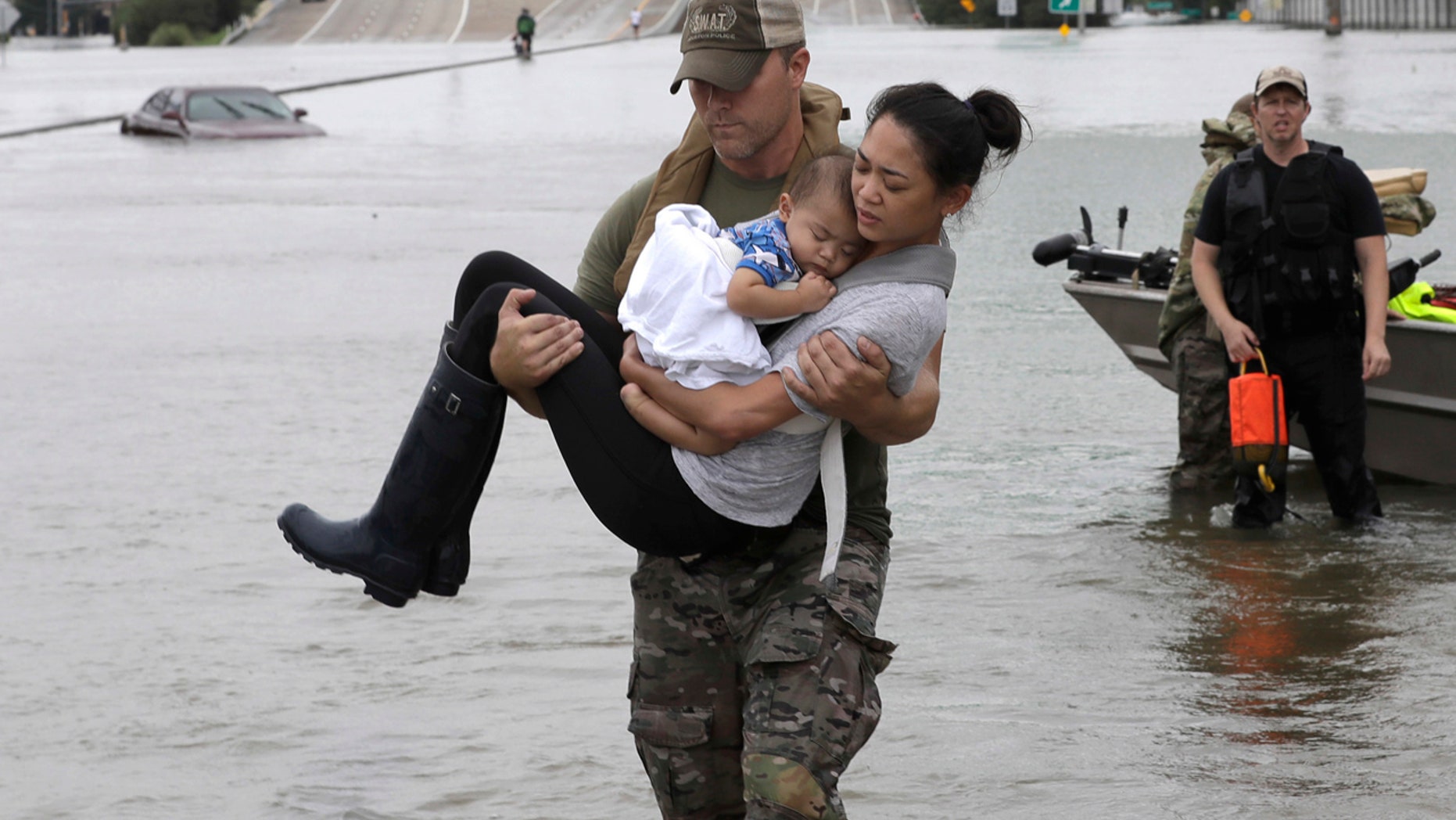 Aug. 27: Houston Police SWAT officer Daryl Hudeck carries Catherine Pham and her 13-month-old son Aiden after rescuing them from their home surrounded by floodwaters from Tropical Storm Harvey