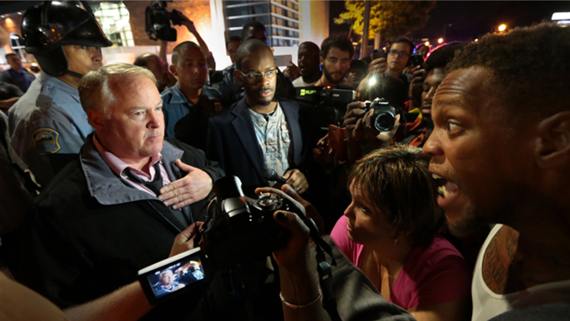Sept. 25, 2014: Ferguson Police Chief Tom Jackson, left, speaks before protesters in front of the Ferguson Police Department.