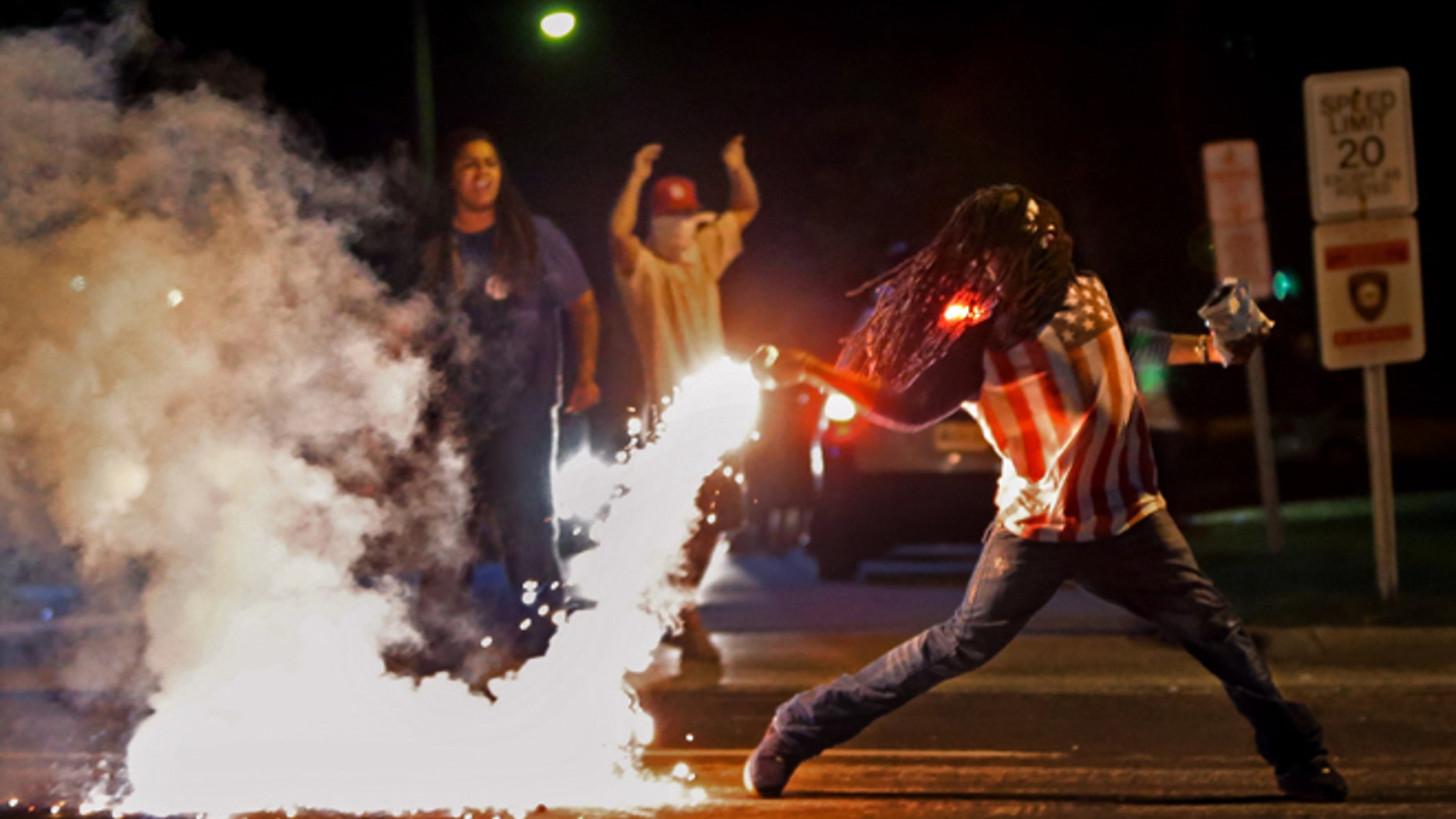 This iconic photo showed Edward Crawford returning a tear gas canister fired by police trying to disperse protesters in Ferguson, Missouri, April 20, 2015. (Robert Cohen/St. Louis Post-Dispatch via AP)