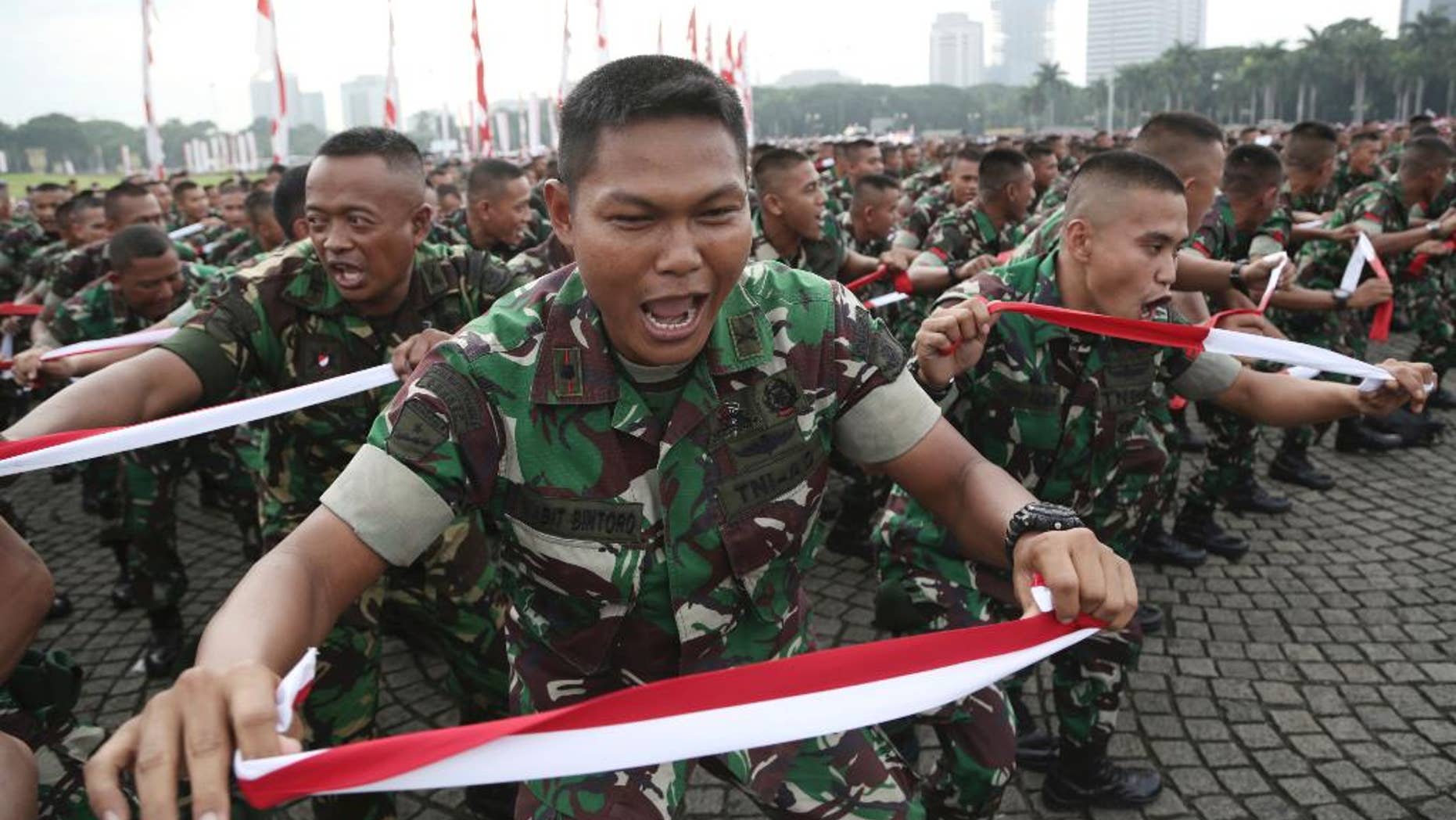 Indonesian soldiers perform national flag -colored headbands during a military-sponsored interfaith rally held ahead of the planned Dec. 2 Muslim protest against Jakarta Governor Basuki Tjahaja Purnama in Jakarta, Indonesia, Wednesday, Nov. 30, 2016. Thousands of Indonesians have joined interfaith rallies around the country organized by the military in an attempt to demonstrate national unity as religious and racial tensions divide the world’s largest Muslim nation. (AP Photo/Achmad Ibrahim)