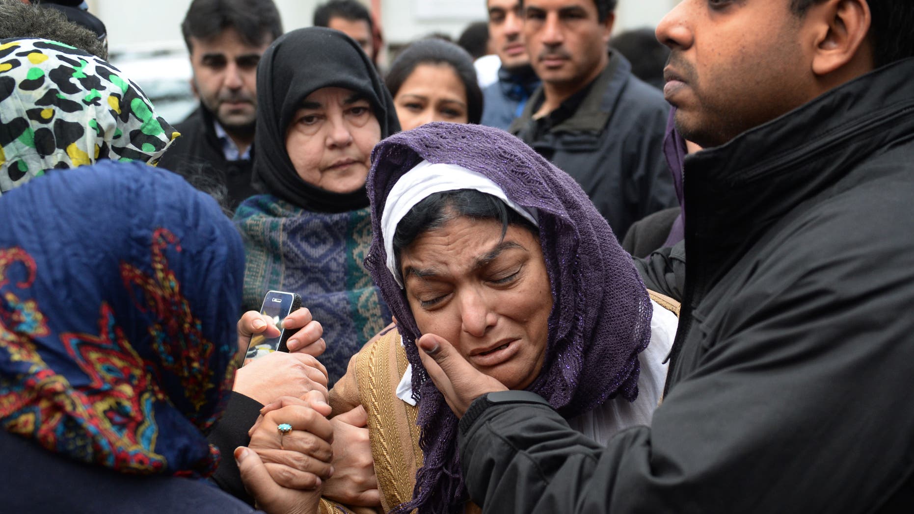 Fatima Khan, mother of Dr Abbas Khan 32, who died while being held in custody in Syria, is comforted by her son at a service for the British doctor at Regent's Park mosque in central London, Thursday, Dec. 26, 2013. Dr Abbas Khan was on the verge of being released when his family were told of his death. The Syrian regime claimed he took his own life but his family claim he was murdered. (AP Photo/Stefan Rousseau, PA Wire) UNITED KINGDOM OUT - NO SALES - NO ARCHIVES