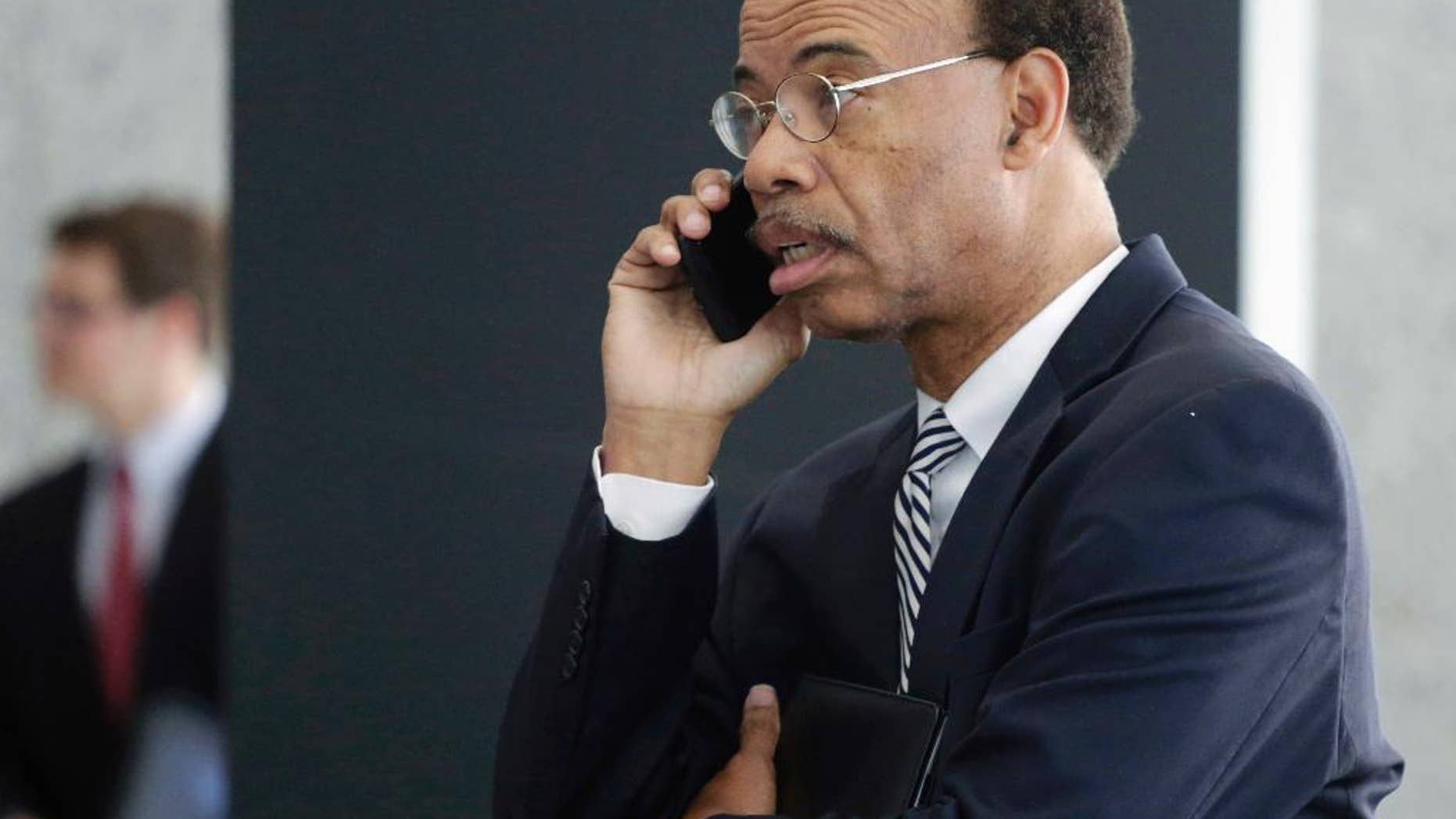FILE - In this July 30, 2015, file photo, former Illinois U.S. Rep. Mel Reynolds talks on his cell phone as he leaves federal court in Chicago. Reynolds says he no longer wants to plead guilty to misdemeanor federal tax charges. In a hand-written court filing Tuesday, May 17, 2016, Reynolds said he wants to be released to a Chicago halfway house where he believes he can better prepare for his June 20 trial. (AP Photo/M. Spencer Green, File)