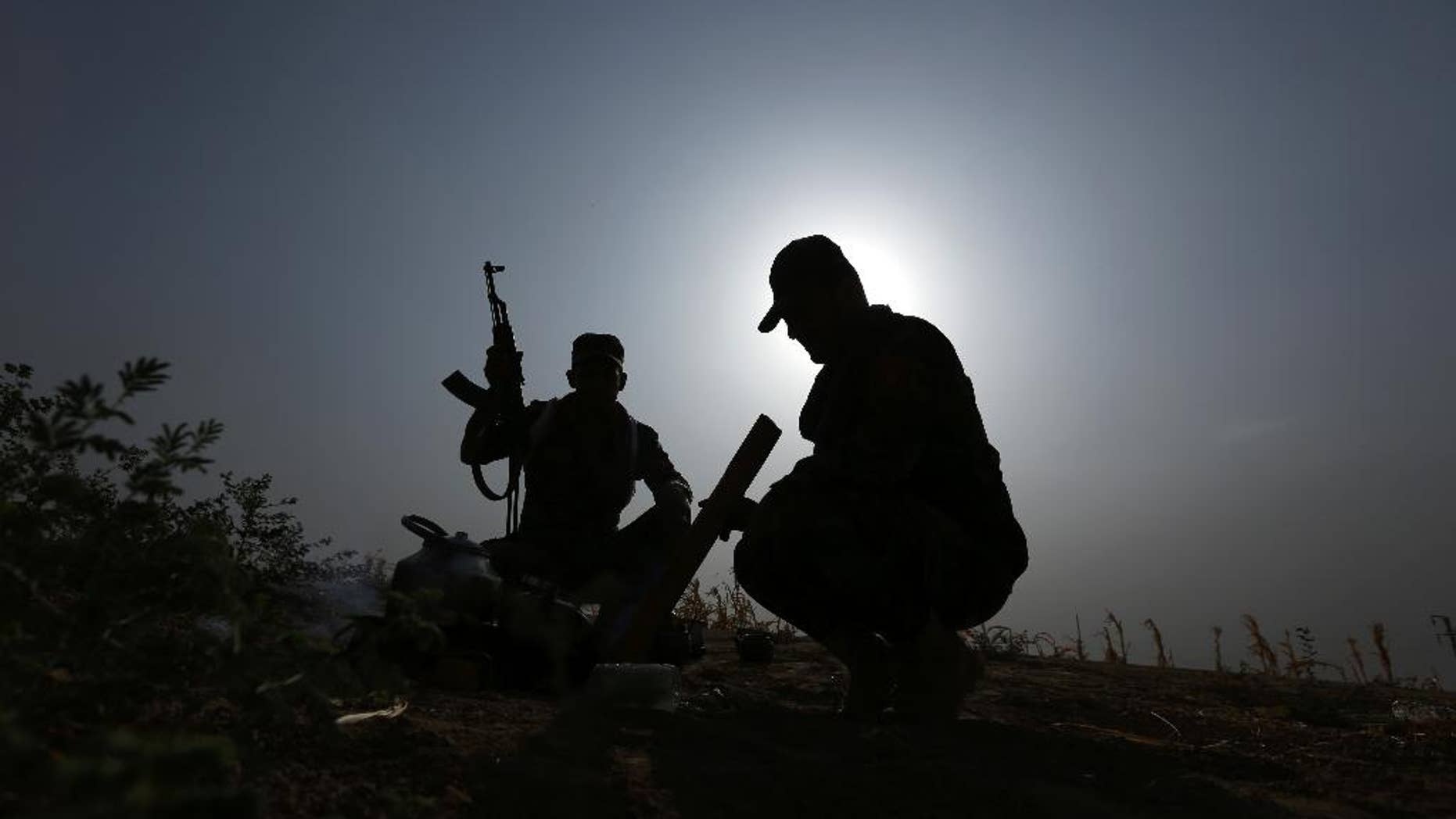 Oct. 1, 2014: Iraqi Kurdish soldiers pause from combat to make tea near to the front line in Mahmoudiyah, Iraq, a day after they take control of the village from the Islamic State group