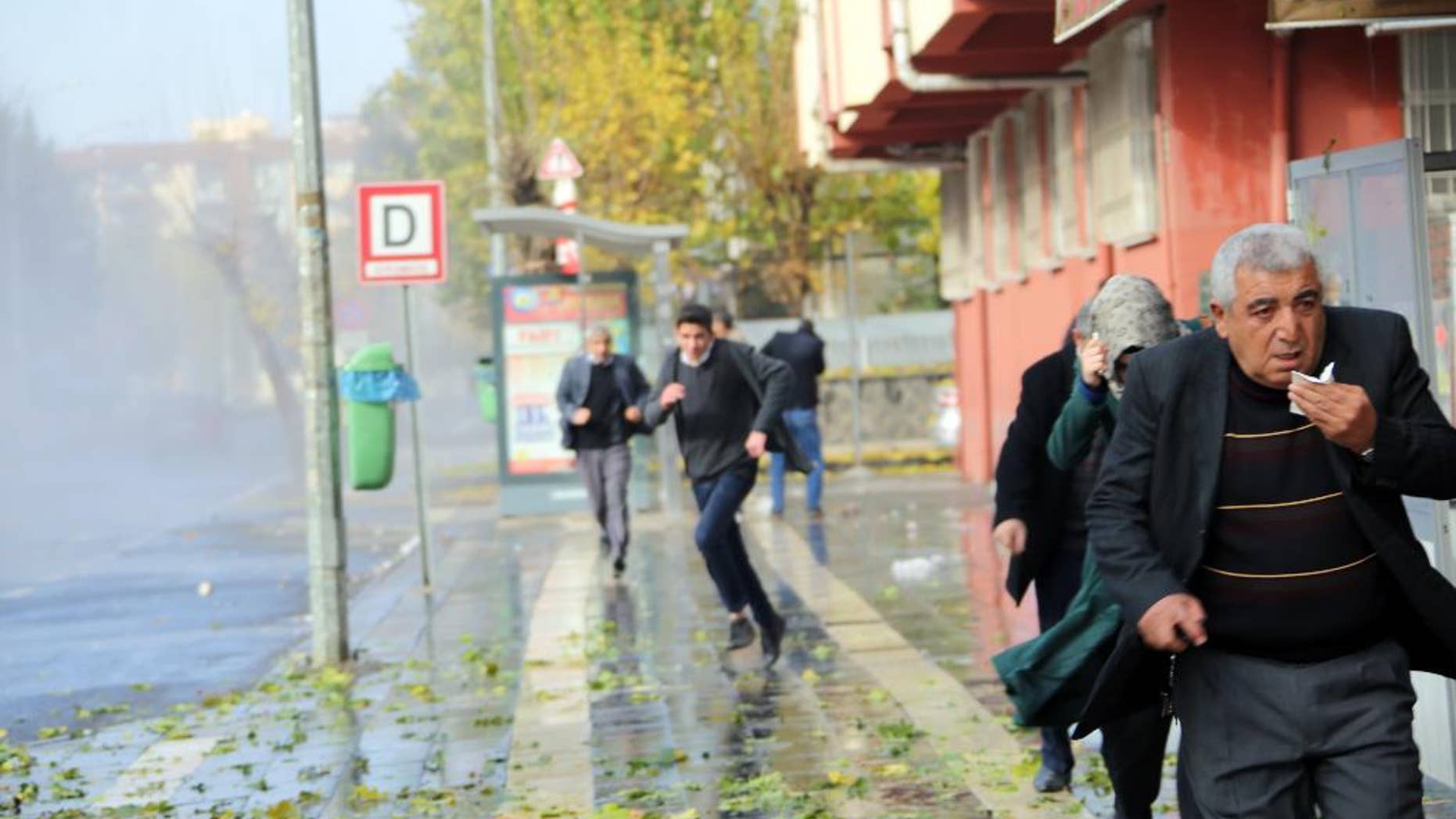 Police use water cannons and teargas to break up a protest by some 5,000 people, denouncing a government-imposed curfew in the historical city center, in Diyarbakir, Turkey, Monday, Dec. 14, 2015. Turkey is imposing dayslong curfews in towns and districts in southeast Turkey as the security forces battle Kurdish militants who dig up ditches or set up barricades.(AP Photo/Mahmut Bozarslan)