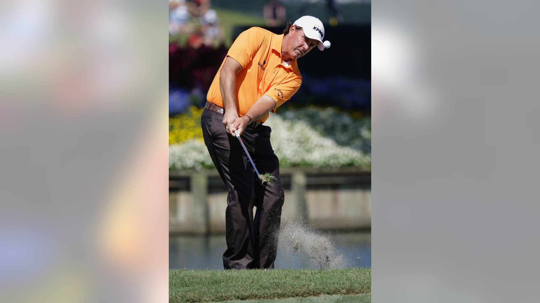 Phil Mickelson chips onto the 16th green during the first round of The Players championship golf tournament at TPC Sawgrass, Thursday, May 8, 2014, in Ponte Vedra Beach, Fla. (AP Photo/John Raoux)