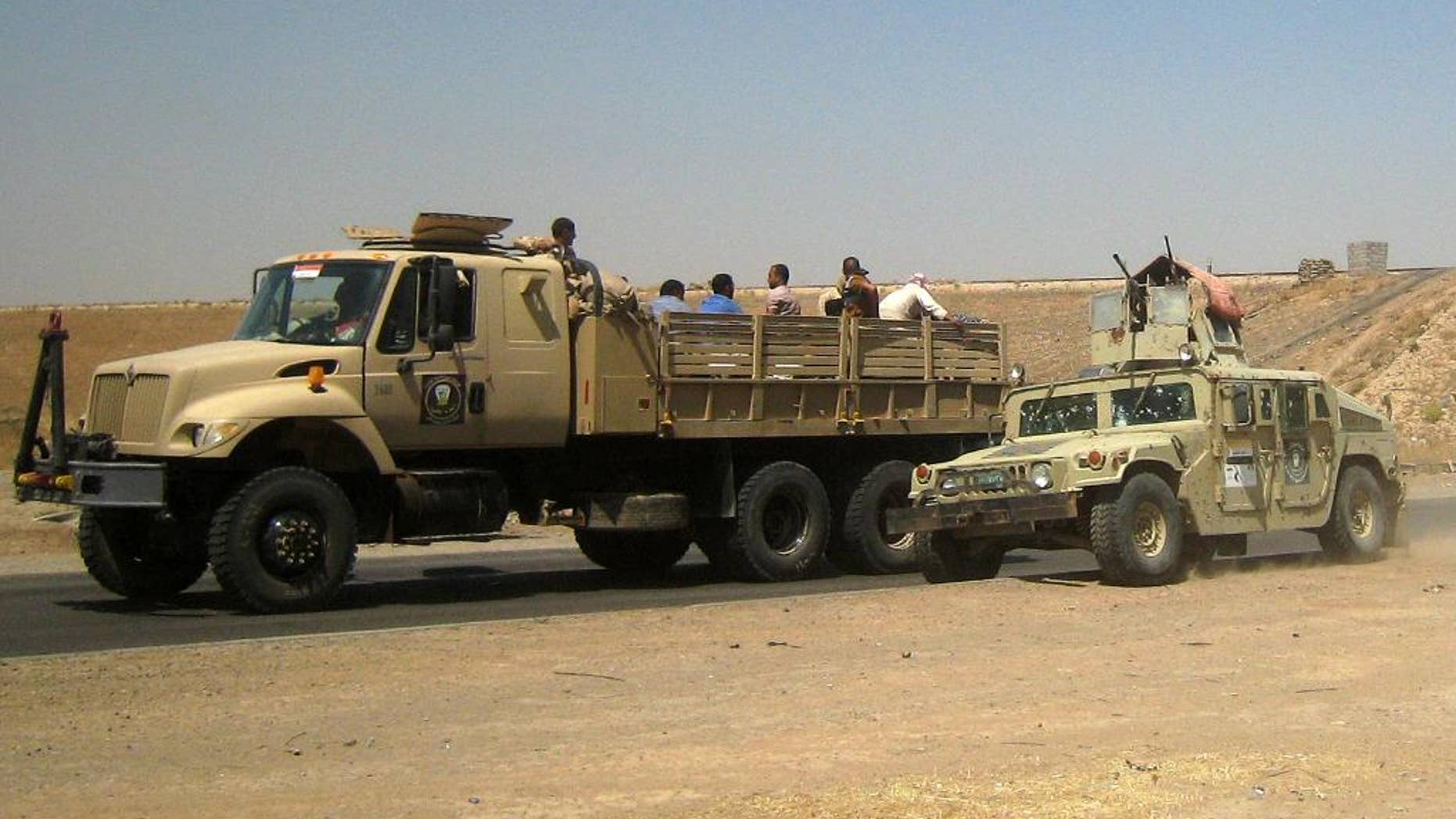 Iraqi security forces in uniforms and plainclothes head to Baghdad in the main road between Baghdad and Mosul, a day after fighters from the Islamic State of Iraq and the Levant took control of much of Mosul, outside Kirkuk, 180 miles (290 kilometers) north of Baghdad, Iraq, Wednesday, June 11, 2014. Al-Qaida-inspired militants seized effective control Wednesday of Saddam Hussein's hometown of Tikrit, expanding their offensive closer to the Iraqi capital as soldiers and security forces abandoned their posts following clashes with the insurgents. (AP Photo)