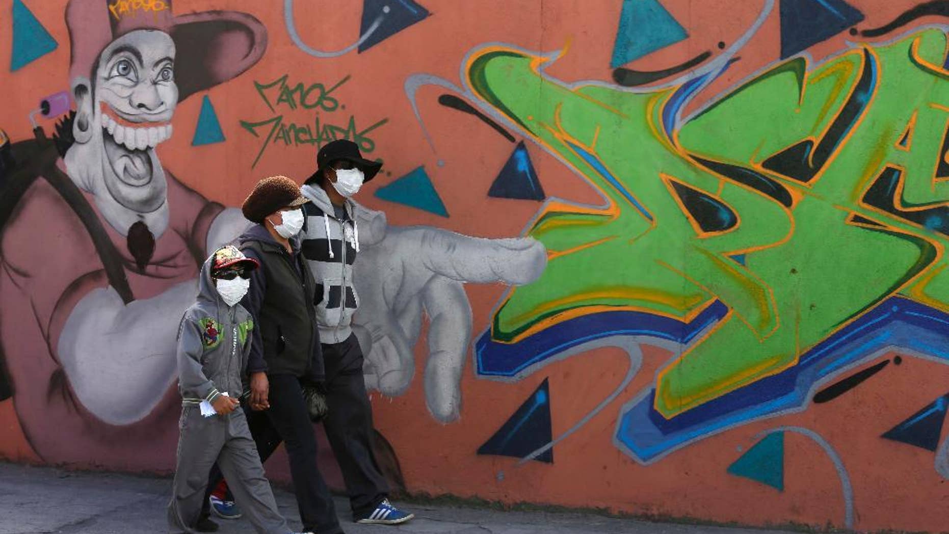 Residents wear masks to protect themselves from volcanic ash spewed from the Cotopaxi volcano, in Machachi, Ecuador, Friday, Aug. 14, 2015. The Cotopaxi volcano near Ecuador's capital has spewed ash over a wide area in two pre-dawn blasts. The volcano is considered one of the world's most dangerous volcanoes due to a glacial cover that makes it prone to mud flows and its proximity to a heavily populated area, but government scientists say that the snow-capped volcano doesn't seem to be on the verge of a major eruption. Its last major eruption was in 1877. (AP Photo/Dolores Ochoa)