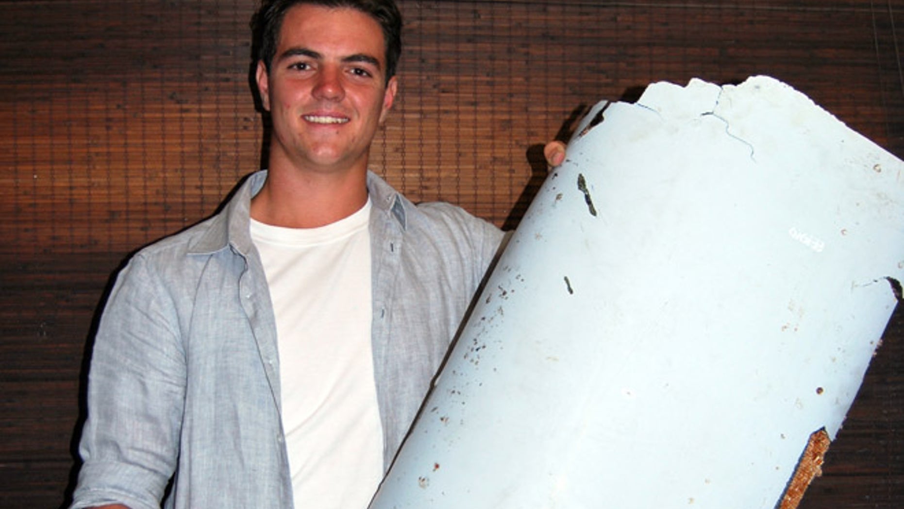 Liam Lotter poses with a piece of debris thought to be part of the missing Malaysia Airlines Flight MH370, in Wartburg, South Africa.