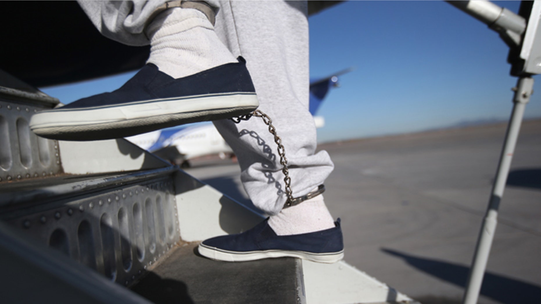 MESA, AZ - FEBRUARY 28: A Honduran immigration detainee, his feet shackled as a security precaution, boards a deportation flight to San Pedro Sula, Honduras on February 28, 2013 in Mesa, Arizona. U.S. Immigration and Customs Enforcement (ICE), operates 4-5 flights per week from Mesa to Central America, deporting hundreds of undocumented immigrants detained in western states of the U.S. With the possibility of federal budget sequestration, ICE released 303 immigration detainees in the last week from detention centers throughout Arizona. More than 2,000 immigration detainees remain in ICE custody in the state. Most detainees typically remain in custody for several weeks before they are deported to their home country, while others remain for longer periods while their immigration cases work through the courts. (Photo by John Moore/Getty Images)