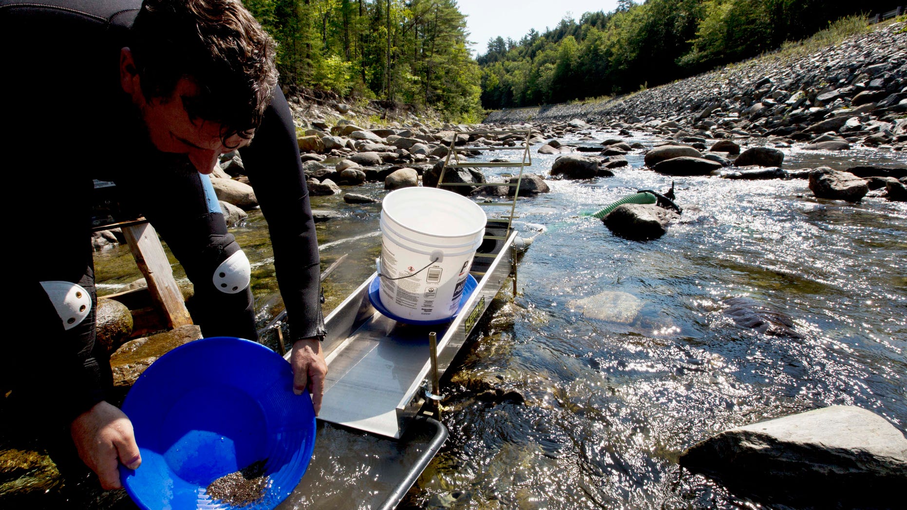 In this photo taken Sunday, Sept. 4, 2016, Chris Hall uses a sluice box to pan for gold in the Wild Ammonoosuc River in Bath, N.H.