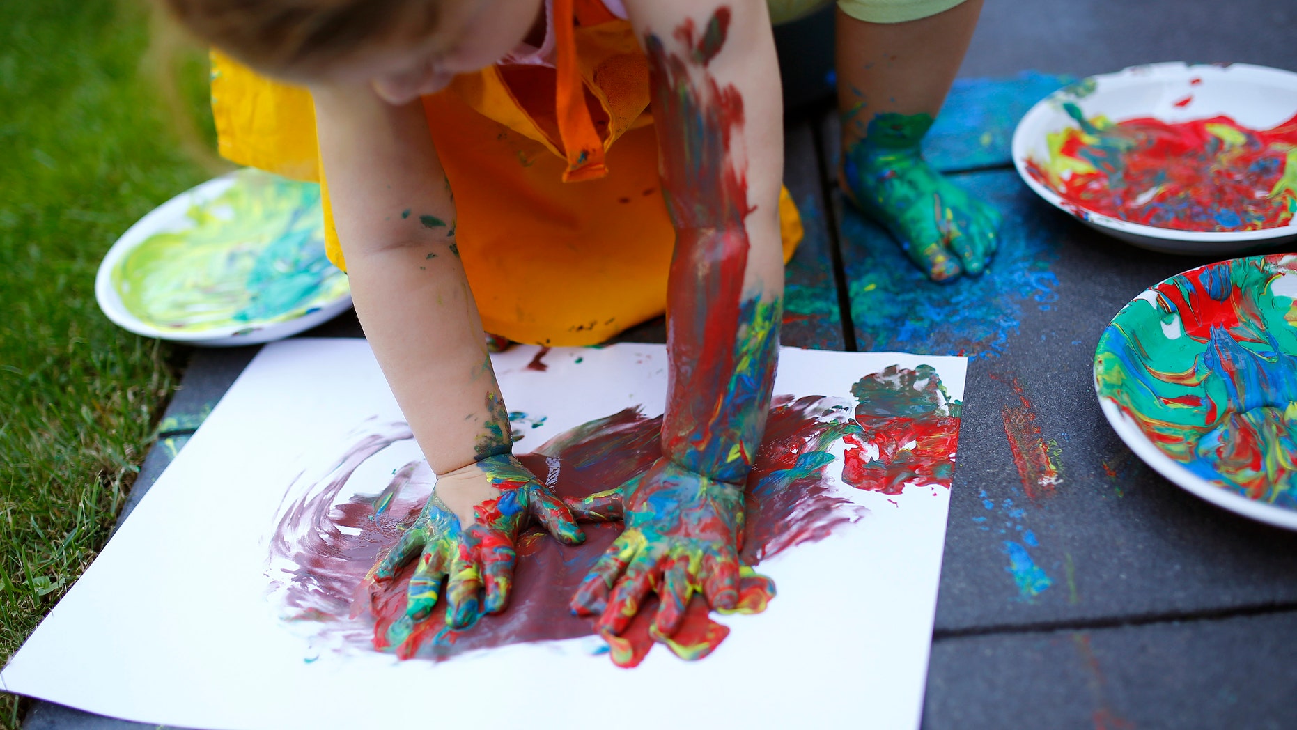 Two year-old Kaethe plays with paints in the garden of her home in Hanau, 30km (18 miles) south of Frankfurt, July 21, 2013. From August 1, 2013, all children in Germany between the age of 1 and 3 will have a legal entitlement to a place at a kindergarten. Picture taken July 21. REUTERS/Kai Pfaffenbach (GERMANY - Tags: POLITICS SOCIETY) - RTX11YEV