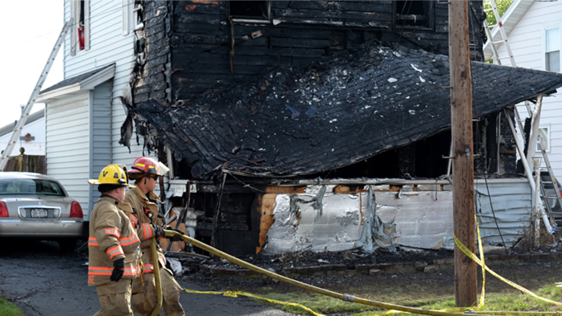 Syracuse firefighters begin to clean up at the scene of a fatal fire, Friday May 6, 2016, in Syracuse, N.Y. The blaze was reported early Friday morning. (Michael Greenlar/The Syracuse Newspapers via AP) NO SALES; MANDATORY CREDIT