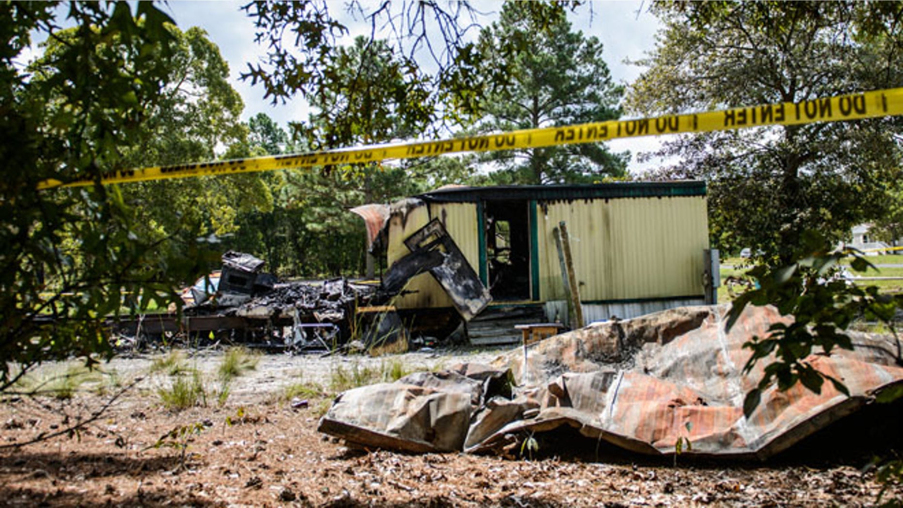 This Saturday, Aug. 30, 2014 photo shows the burned remains of a mobile home in Garland, N.C. An early Saturday fire killed six people inside, authorities said. (AP Photo/The Fayetteville Observer, James Robinson)