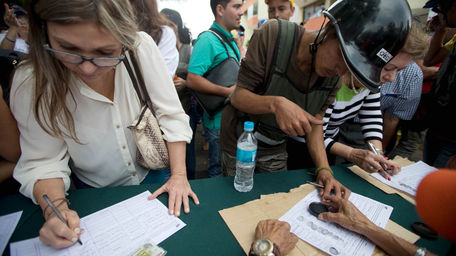 Venezolanos firman una petición que promueve la oposición, para iniciar un referendo revocatorio del mandato del presidente de Venezuela Nicolás Maduro en San Cristóbal, el miércoles 27 de abril de 2016. (Foto AP/Fernando Llano)