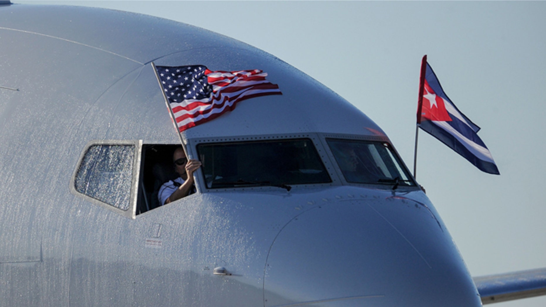 TOPSHOT - An American Airlines plane fluttering US and Cuba national flags is seen uppon arrival at Jose Marti International Airport becoming the first Miami-Havana commercial flight in 50 years, coinciding with the beginning of the tributes to late Cuban leader Fidel Castro, on November 28, 2016 in Havana. / AFP / YAMIL LAGE (Photo credit should read YAMIL LAGE/AFP/Getty Images)