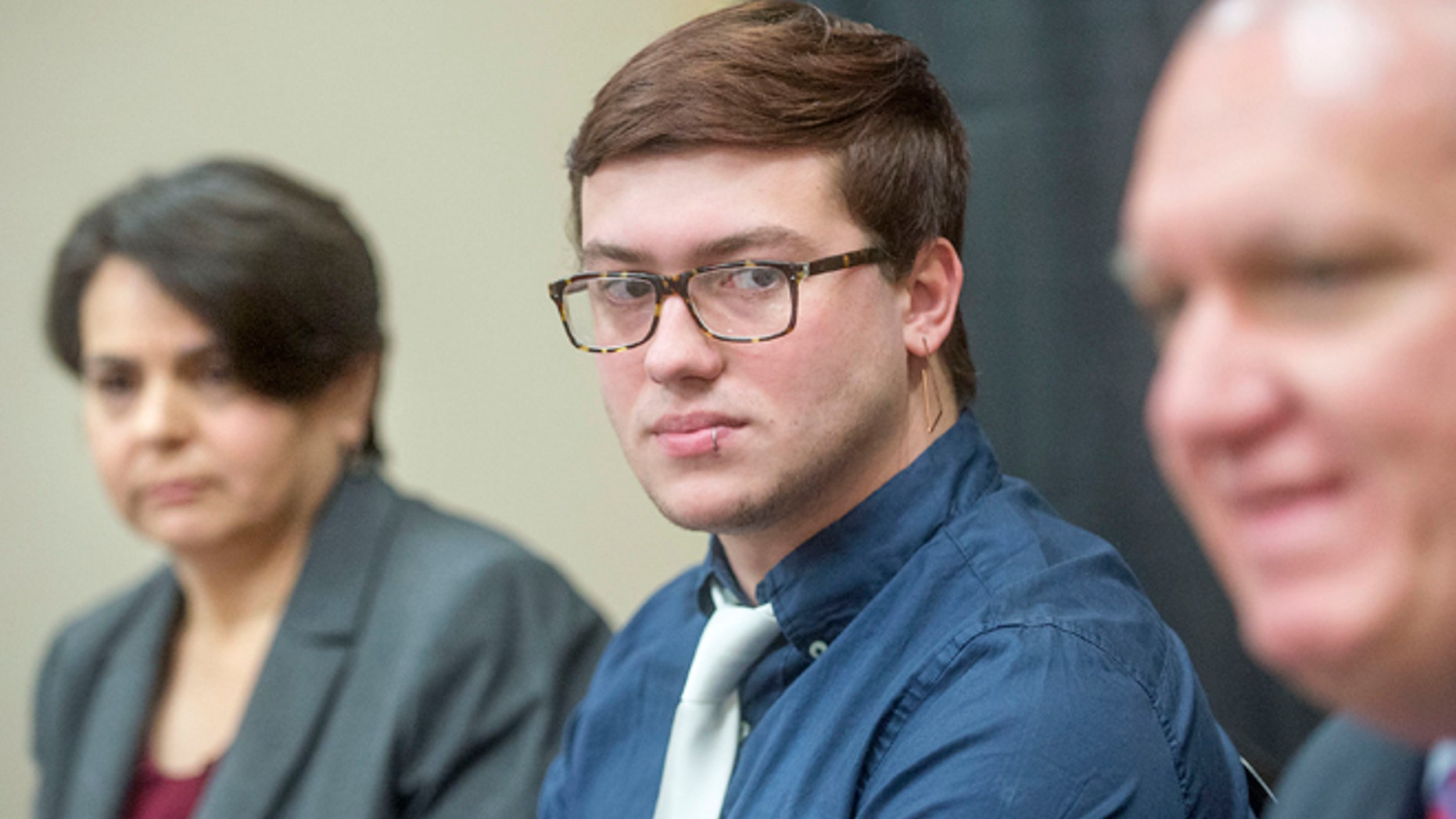 Attorney Rebecca Glenberg, left, with the ACLU, and Bryton Mellott, center, of Urbana, Ill., listen to Ed Yohnka, right, director of communications with the ACLU, during a news conference Thursday, Jan. 12, 2017 in Champaign, Ill.