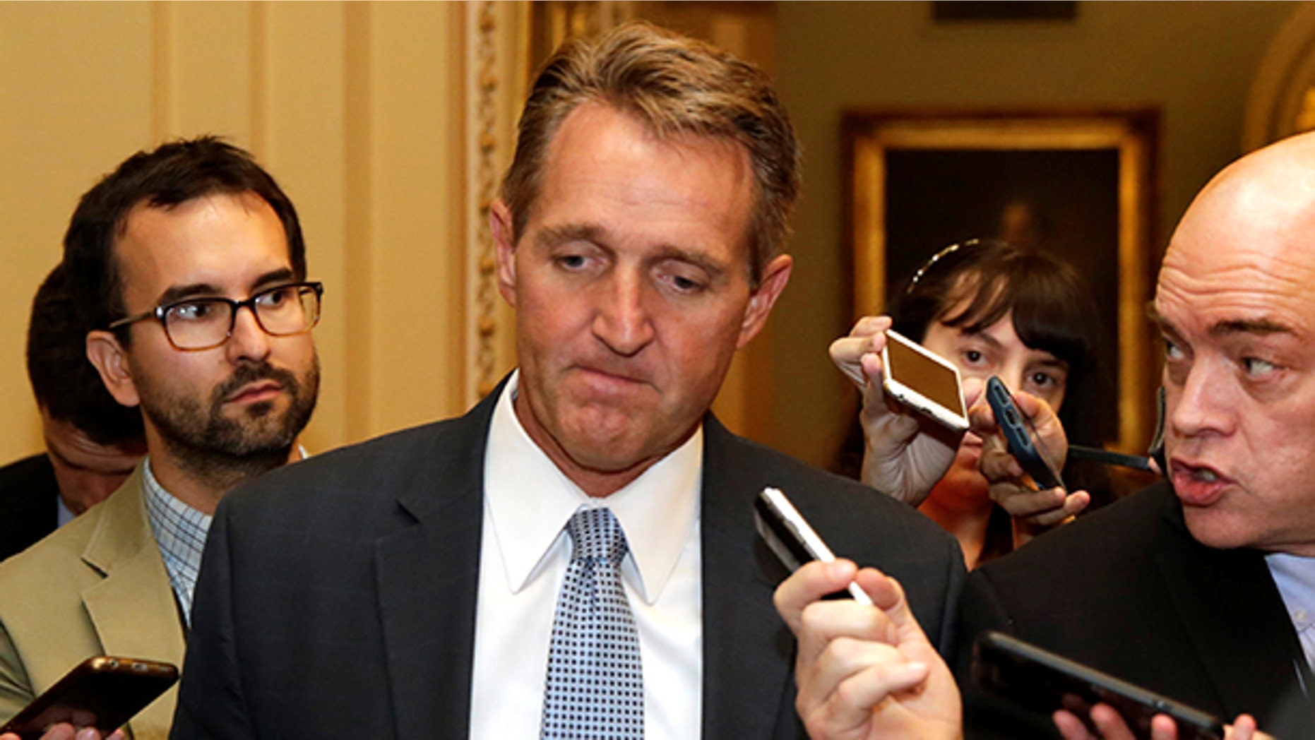 Senator Jeff Flake (R-AZ) talks to reporters as he arrives for a Senate health care vote on Capitol Hill in Washington, U.S., July 27, 2017. REUTERS/Yuri Gripas - RTX3D760