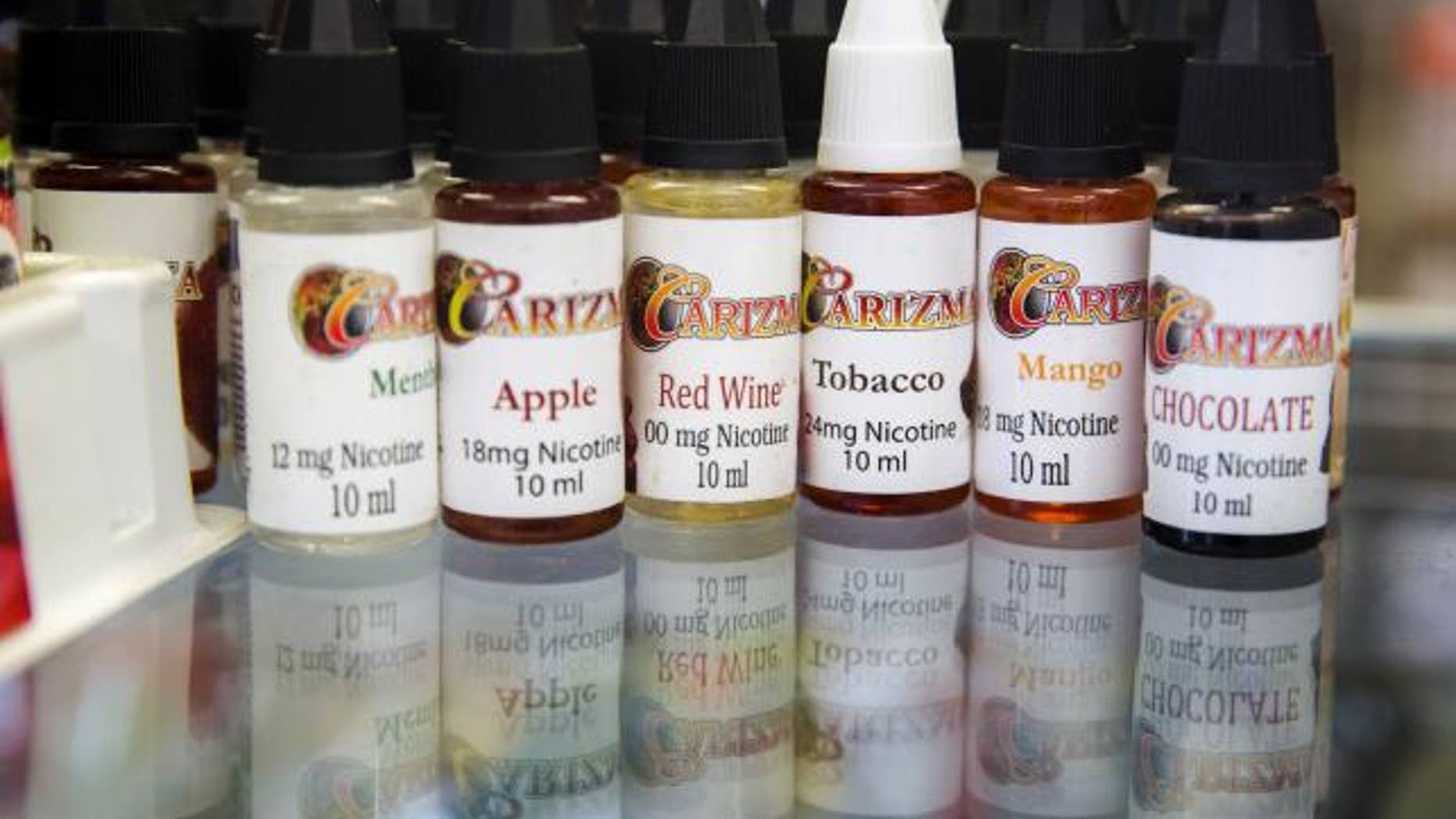 June 23, 2015: Bottles of flavor packets for e-cigarettes stand displayed in a tobacco shop in New York.