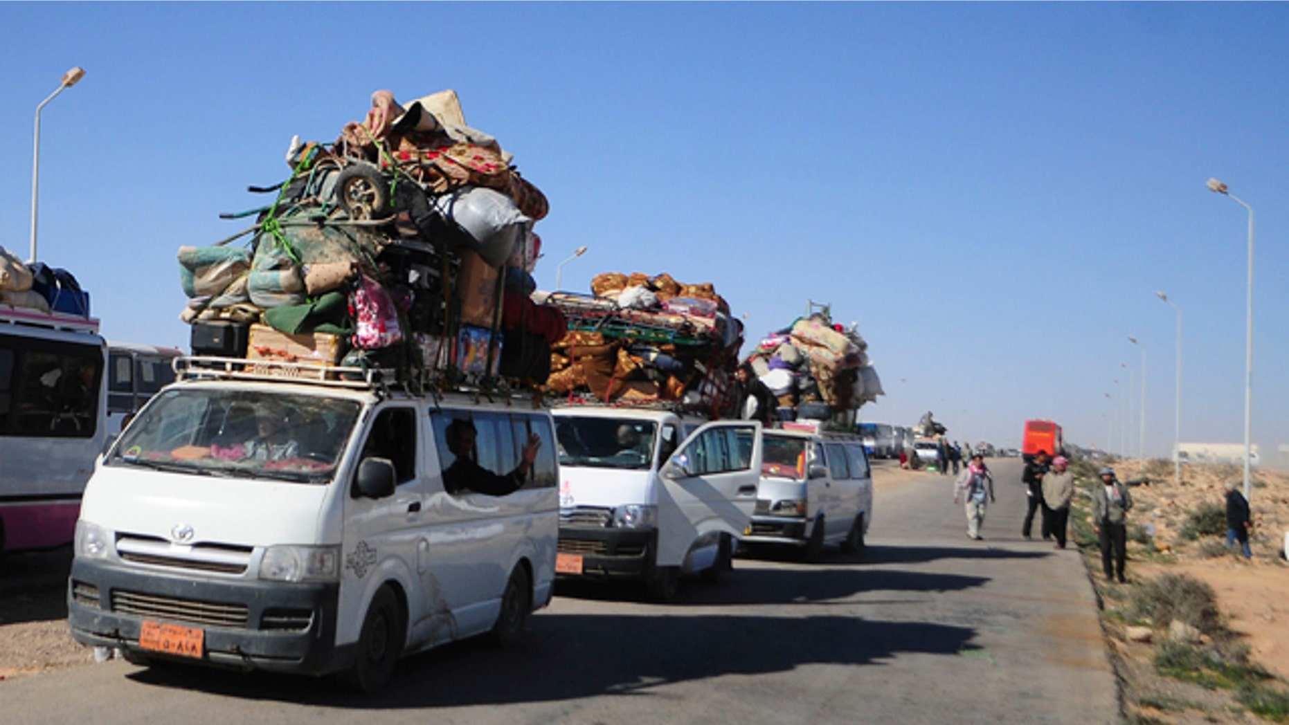 Feb. 23, 2011: Egyptians, who have just crossed Salloum land port gate with Libya arrange their luggage on a mini bus. Turkey evacuated 3,000 citizens on two ships Wednesday from the chaos of Libya's uprising but thousands of other foreigners were still stranded at Tripoli airport, struggling to get a flight home.