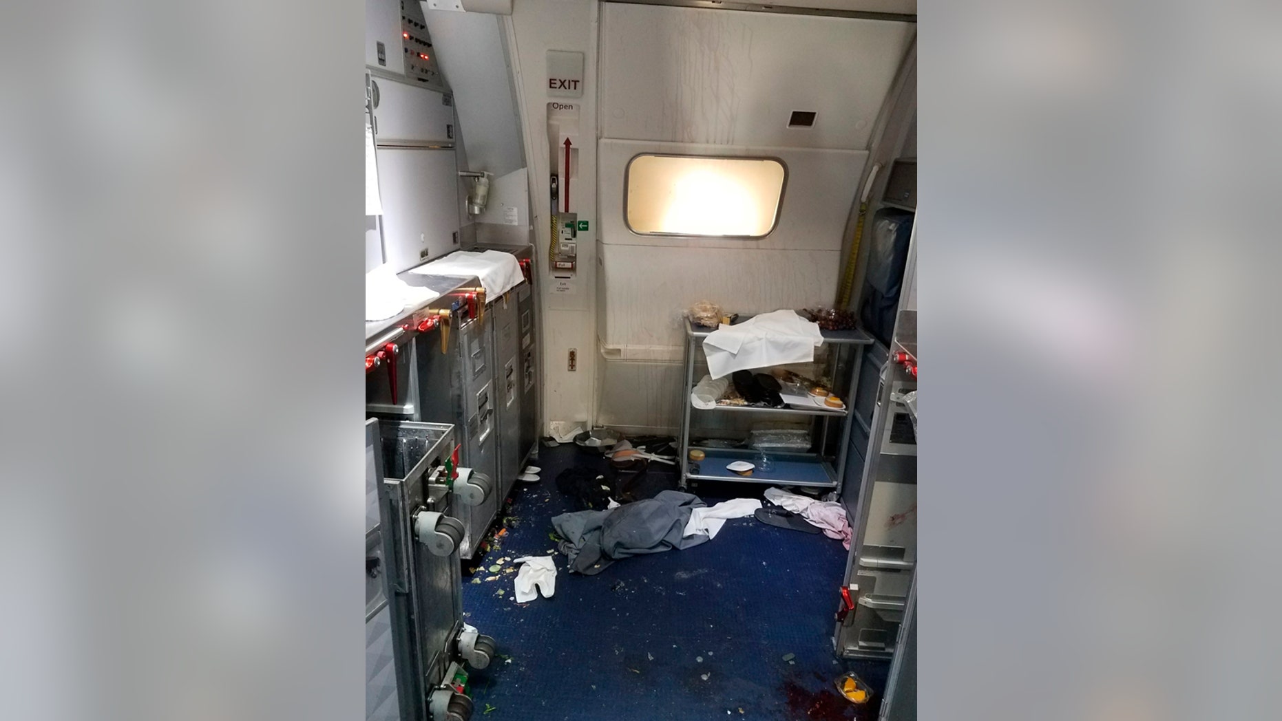 This Friday, July 7, 2017 photo taken the FBI and released via the U.S. Attorney's Office in Seattle shows the aftermath of a cabin on Delta Flight 129 from Seattle to Beijing, after authorities say flight attendants struggled with Joseph Daniel Hudek IV, a passenger who lunged for an exit door. The photo was included in a criminal complaint filed Friday, July 7. The passenger is charged with interfering with a flight crew and faces up to 20 years in prison. (FBI via U.S. Attorney's Office in Seattle via AP)