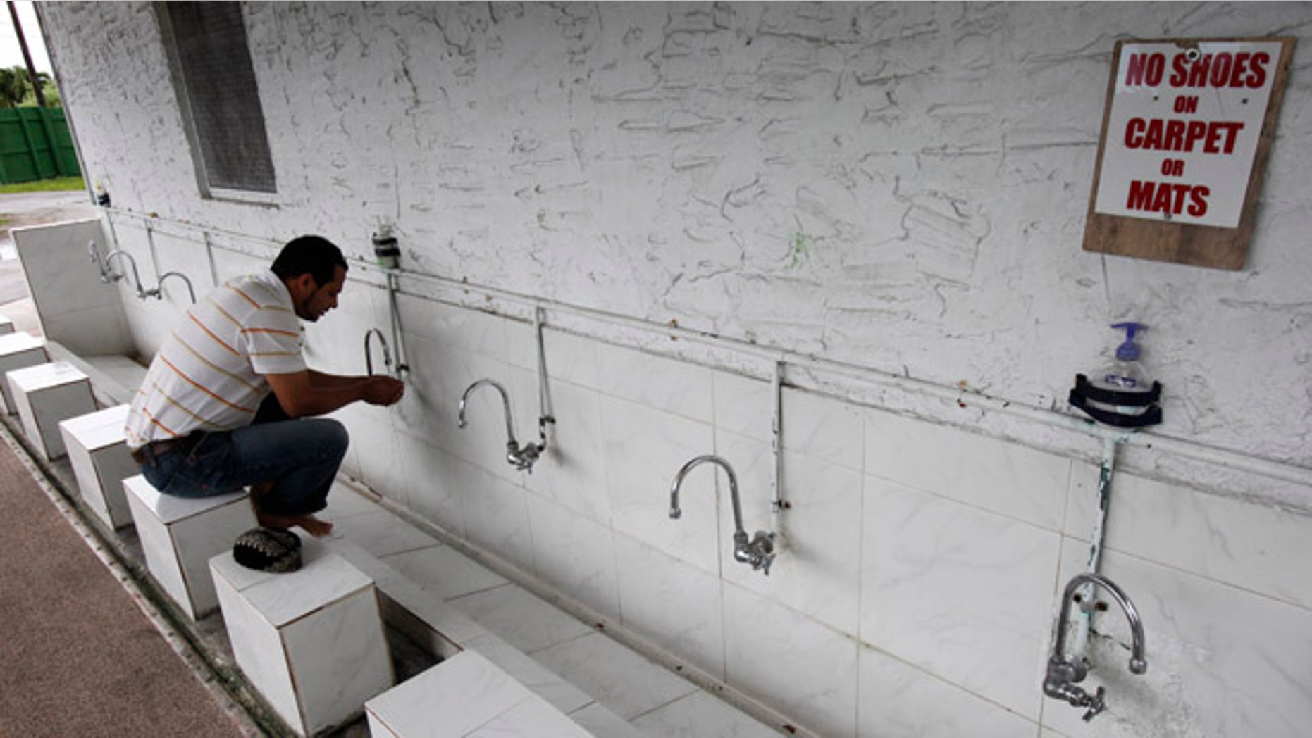May 15: A man washes outside before entering the Miami Mosque, also known as the Flagler Mosque, in Miami. An elderly imam and two of his sons have been arrested on federal charges they provided some $50,000 to the Pakistani Taliban, while three others in Pakistan have been indicted on charges of handling distribution of the funds, authorities say.