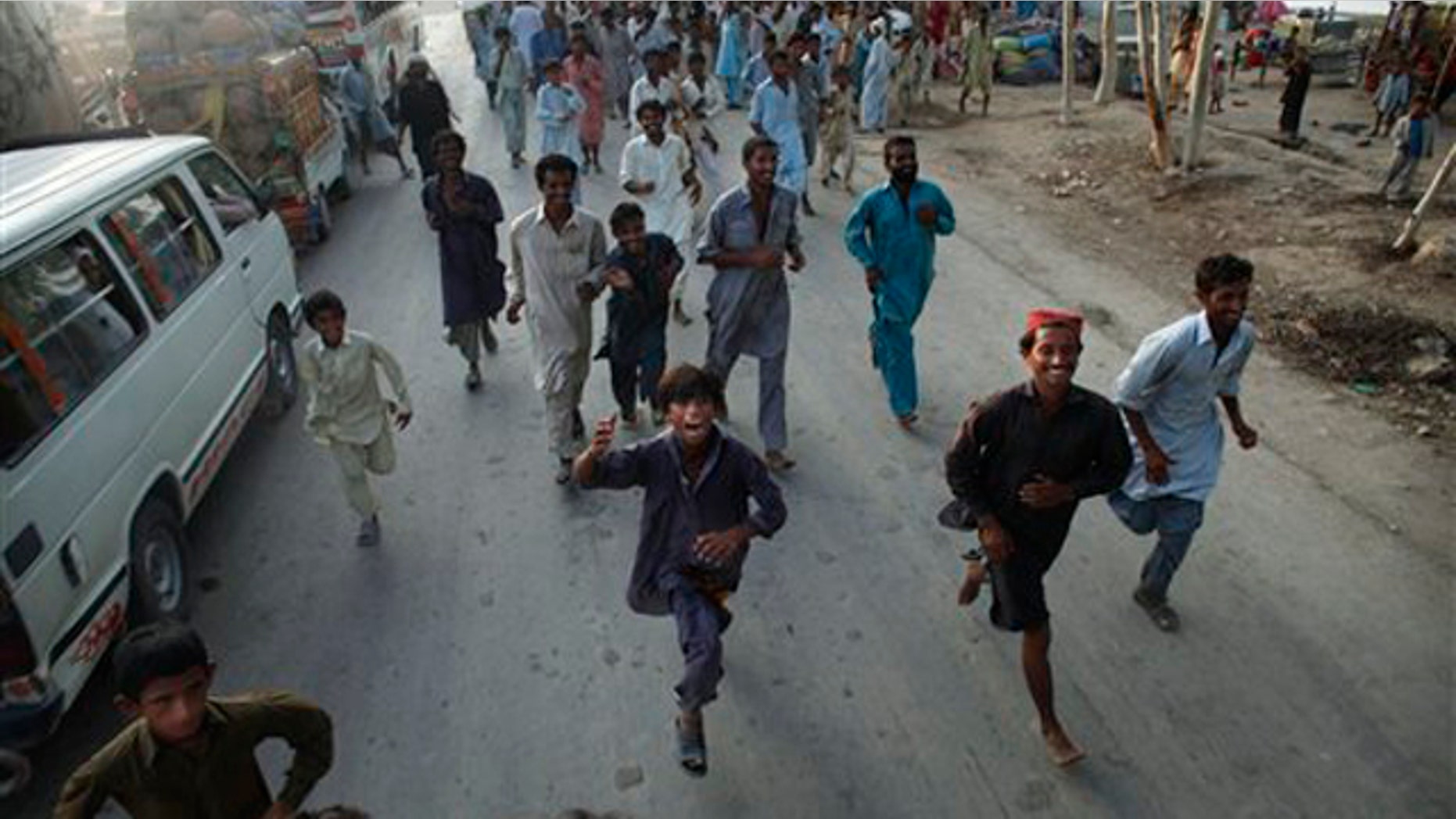 Pakistanis displaced by flooding chase a truck during an aid distribution by the Pakistani Air Force near a camp set up for refugees from Sukkar, Sindh Province, southern Pakistan Aug. 19. (AP Photo)