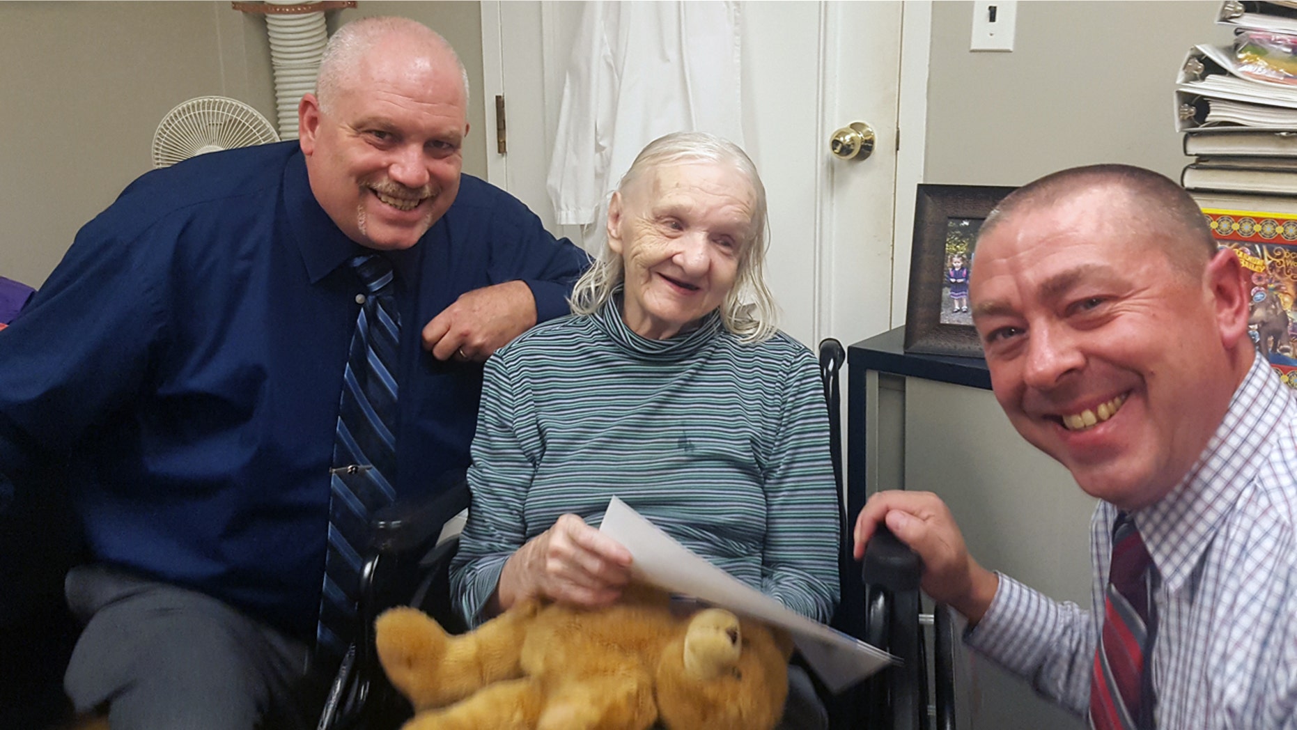 Flora Stevens poses with Sullivan County (NY) Sheriff's Detectives Ed Clouse, left, and Richard Morgan in Lowell, Mass.