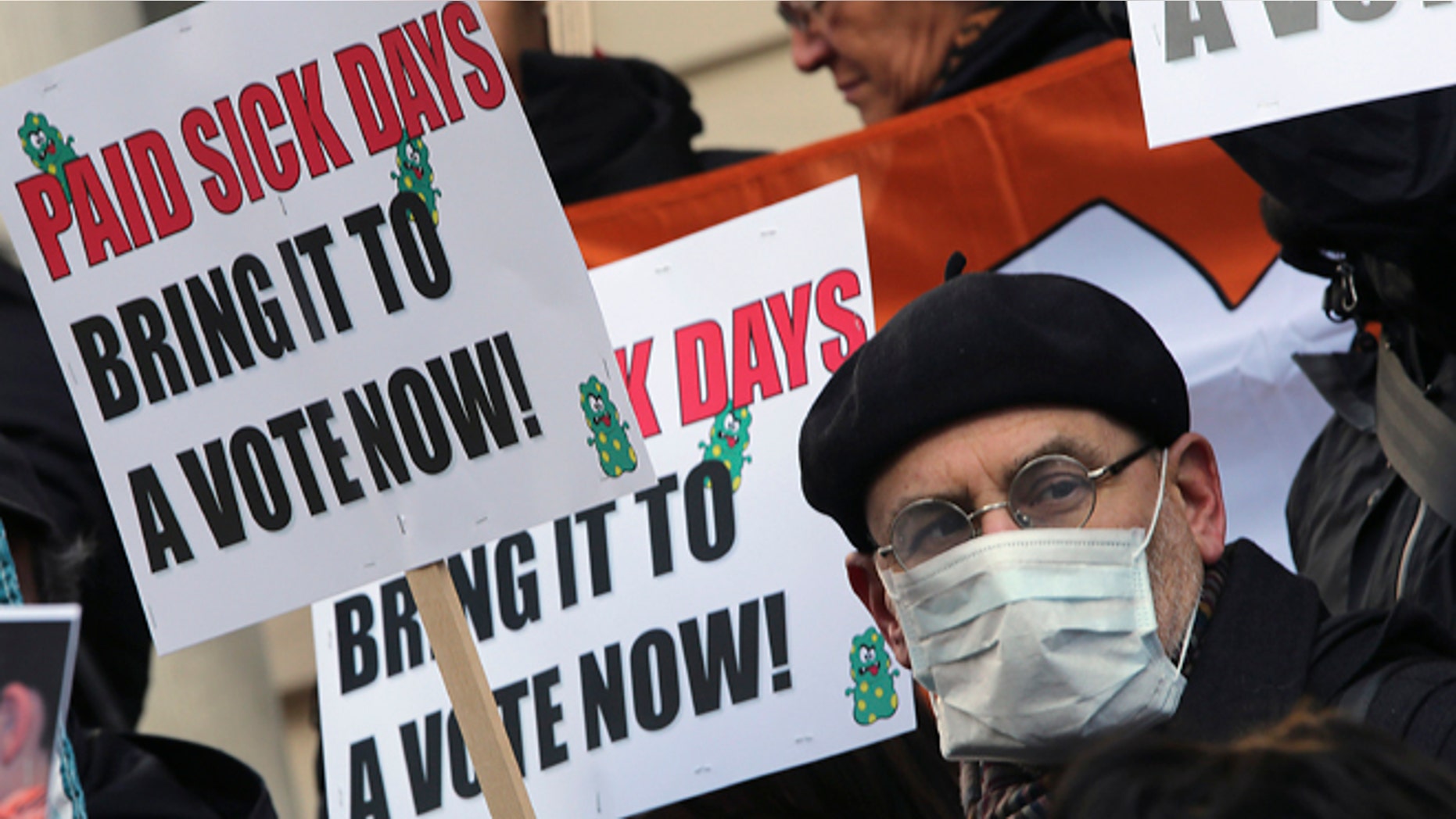 Jan. 18 2013 : In this photo, activists hold signs during a rally at New York's City Hall to call for immediate action on paid sick days legislation in light of the continued spread of the flu.