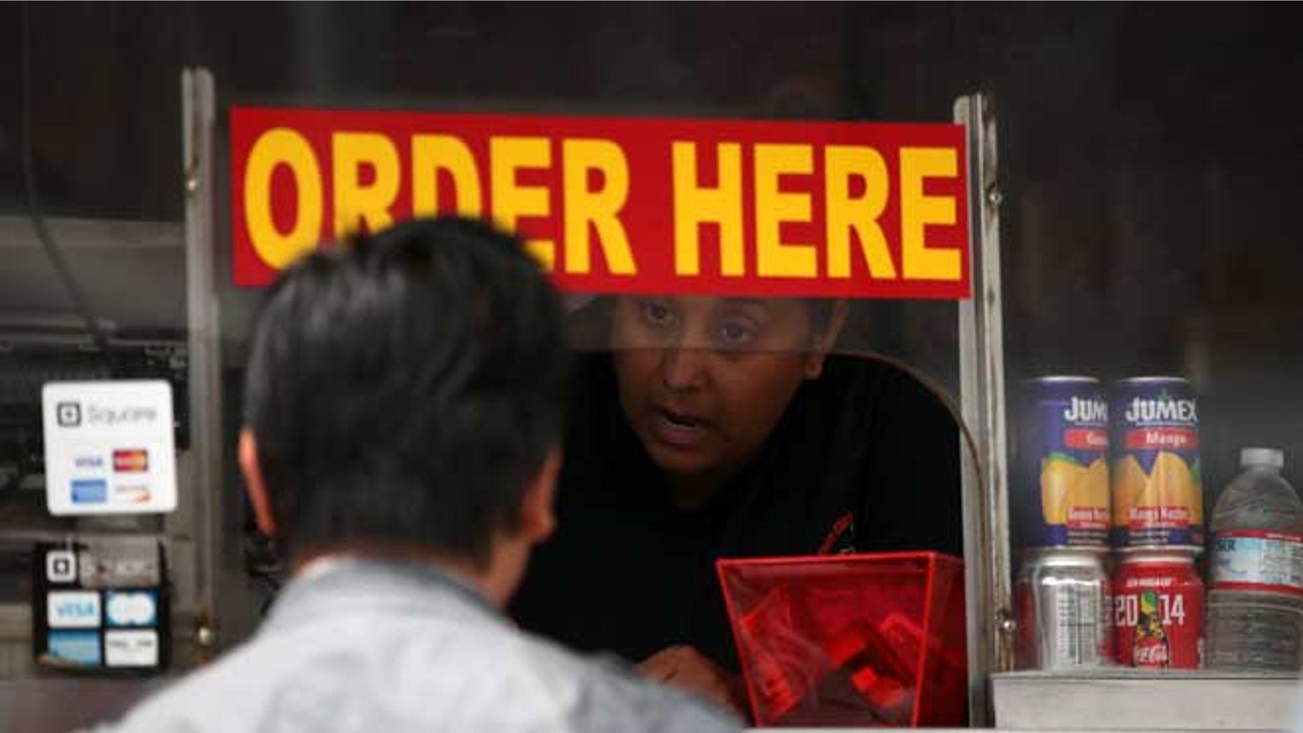 SAN FRANCISCO, CA - JULY 07: A customer places an order at the Tandoori Chicken USA food truck during an Off the Grid "market" on July 7, 2014 in San Francisco, California. Popular San Francisco Bay Area food trucks are gathering at venues organzined by planning companies such Off the Grid that creates "markets" for food trucks for a nominal fee that is far less than fines that are often handed out to food trucks that operate on city streets without proper permits. (Photo by Justin Sullivan/Getty Images)