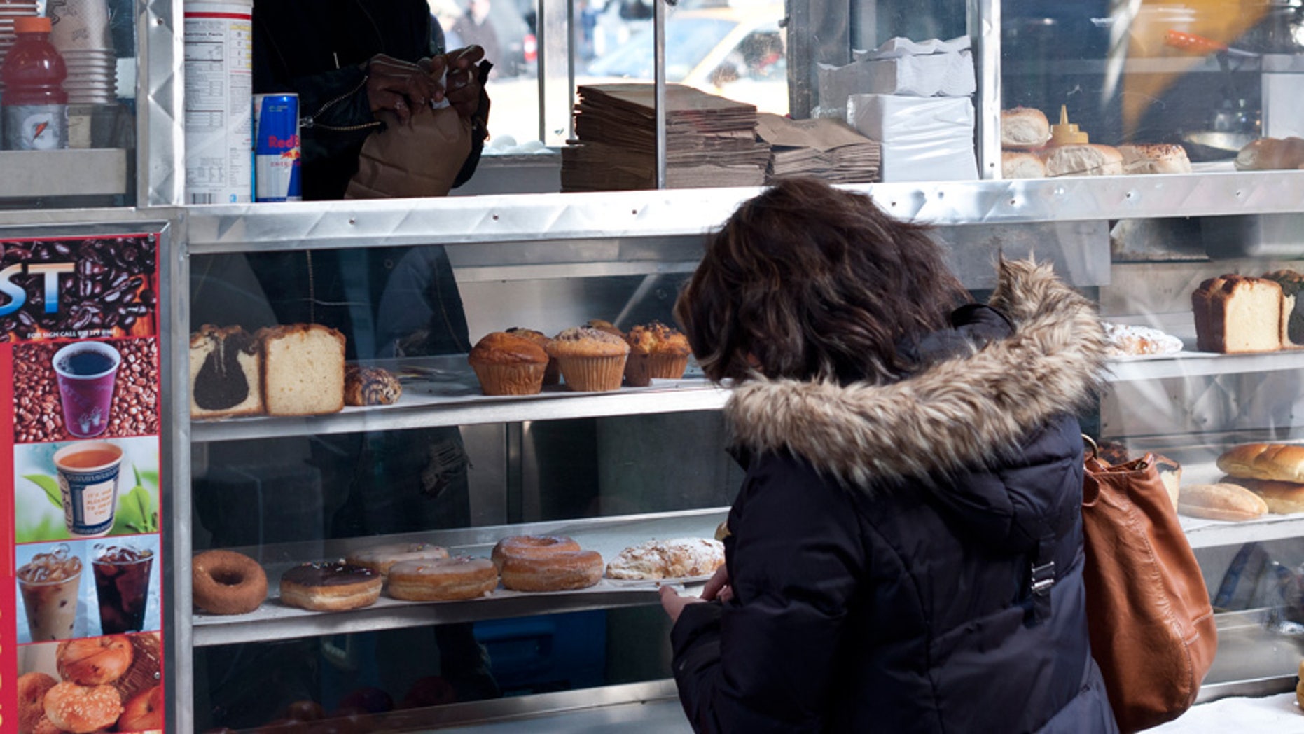 A vendor sells baked goods at a New York City food cart.