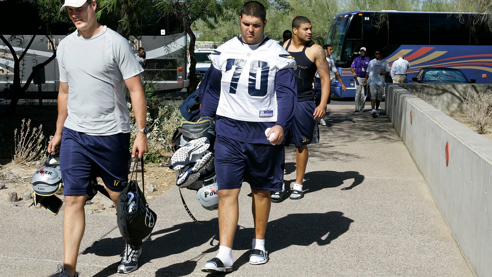 FILE - In this Oct. 24, 2007 file photo, San Diego Chargers' Philip Rivers, left, Shane Olivea (70) and Shawne Merriman, right, arrive for practice with teammates and coaches at the Arizona Cardinals training facility in Tempe, Ariz. Olivea, whose NFL career fell apart because of a painkiller addiction says he wants to become a college coach and help others avoid similar pitfalls now that he's clean and has a degree. (AP Photo/Ross D. Franklin)
