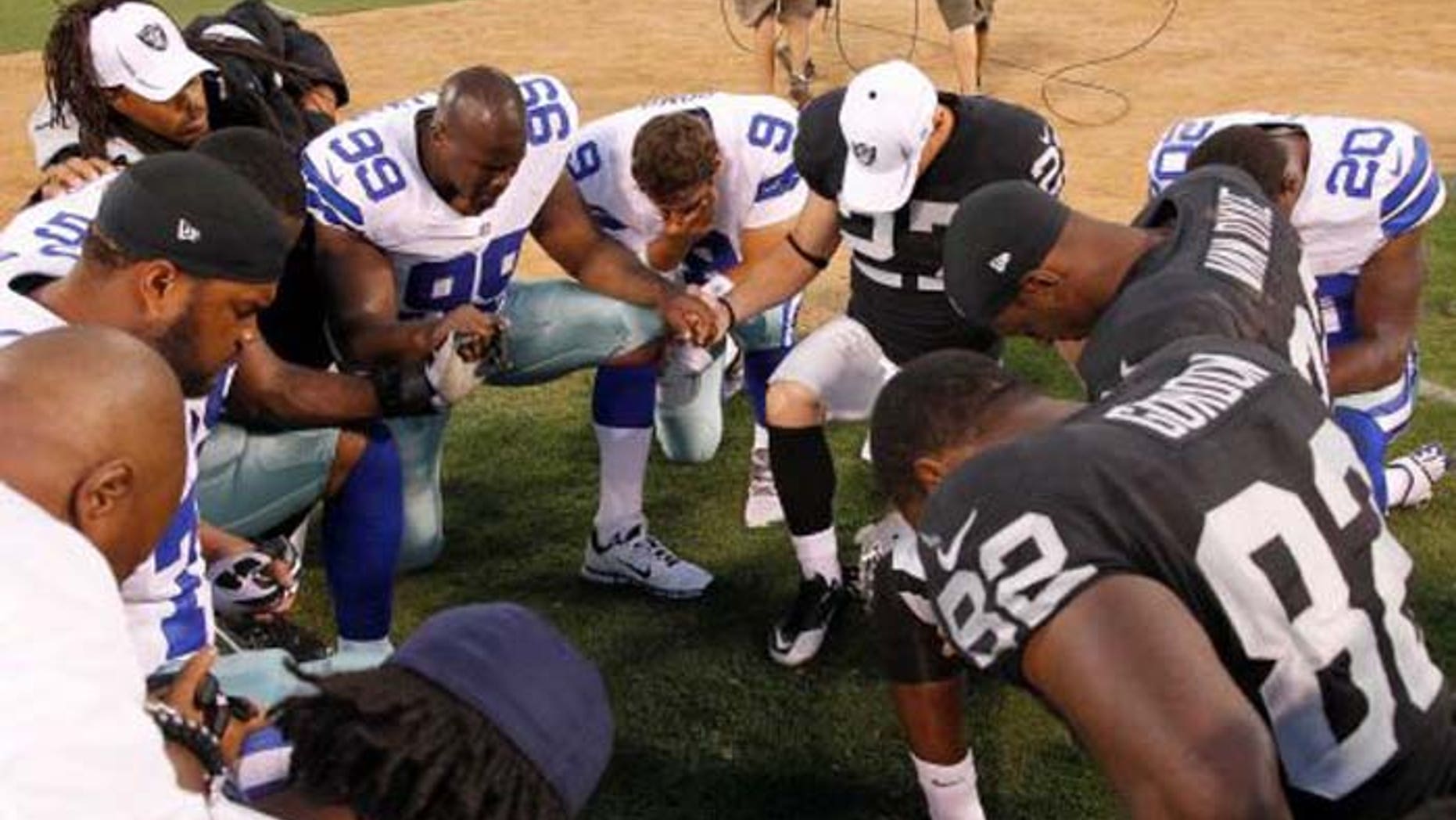 Praying after games is a football tradition, as seen here following an NFL contest between the Dallas Cowboys and the Oakland Raiders. (AP)