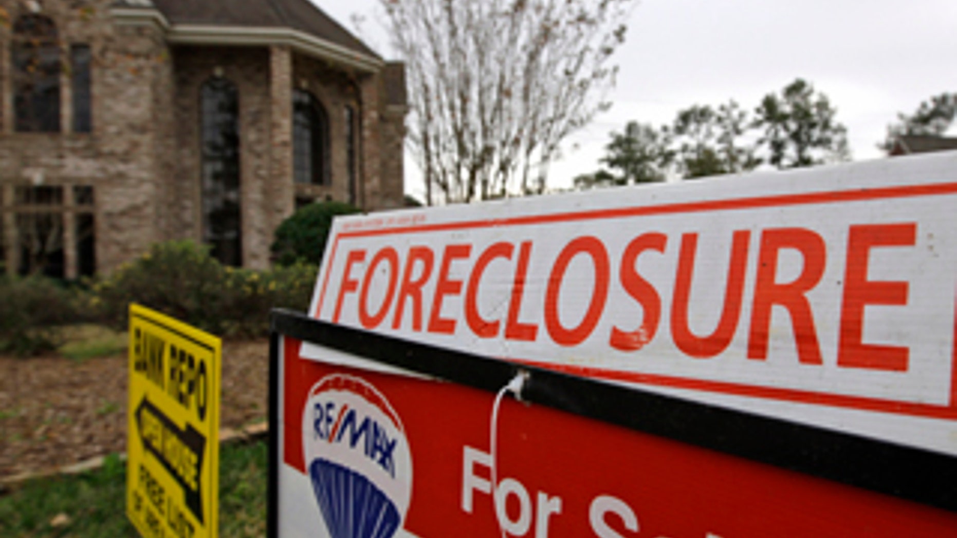 Jan. 20, 2009: Bank repo, foreclosure and for sale signs sit outside a foreclosed home in Houston.