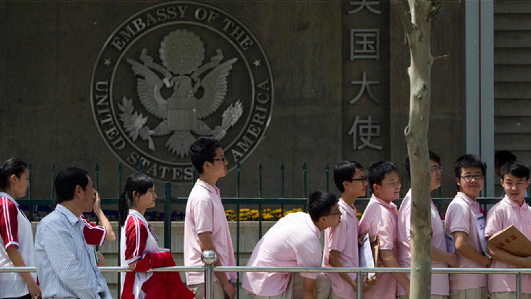 In this May 2012 file photo, Chinese students wait outside the U.S. Embassy for their visa application interviews in Beijing, China, Wednesday, May 2, 2012. Hundreds of thousands of Chinese students are flocking to U.S. colleges and universities, helping to drive the number of international students studying in America to record levels, according to a report to be released Monday.