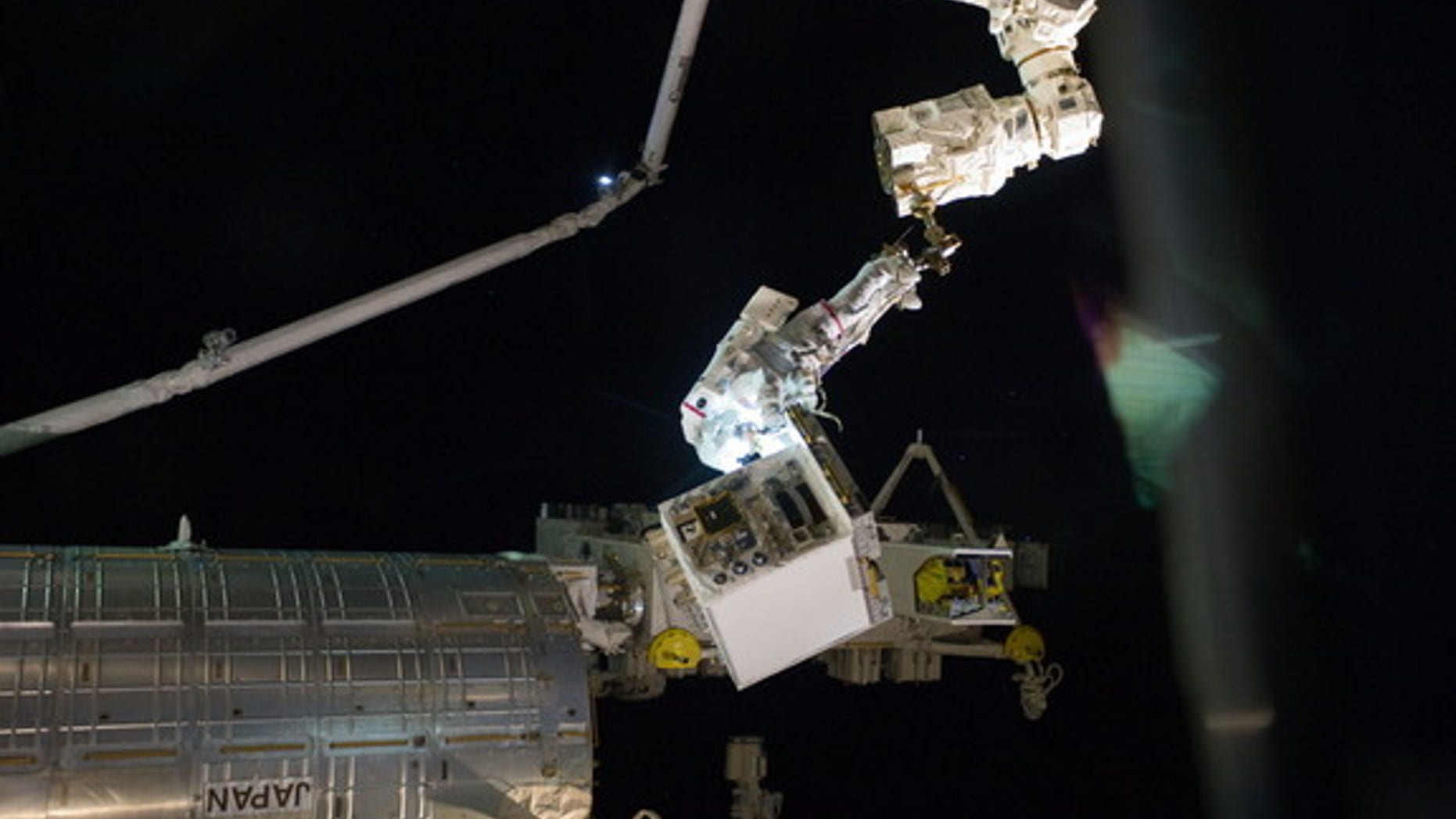 With his feet secured on a restraint on the space station's Canadarm2, NASA astronaut Mike Fossum holds the Robotics Refueling Mission payload, which was the focus of one of the primary chores accomplished on a six and a half hour spacewalk on