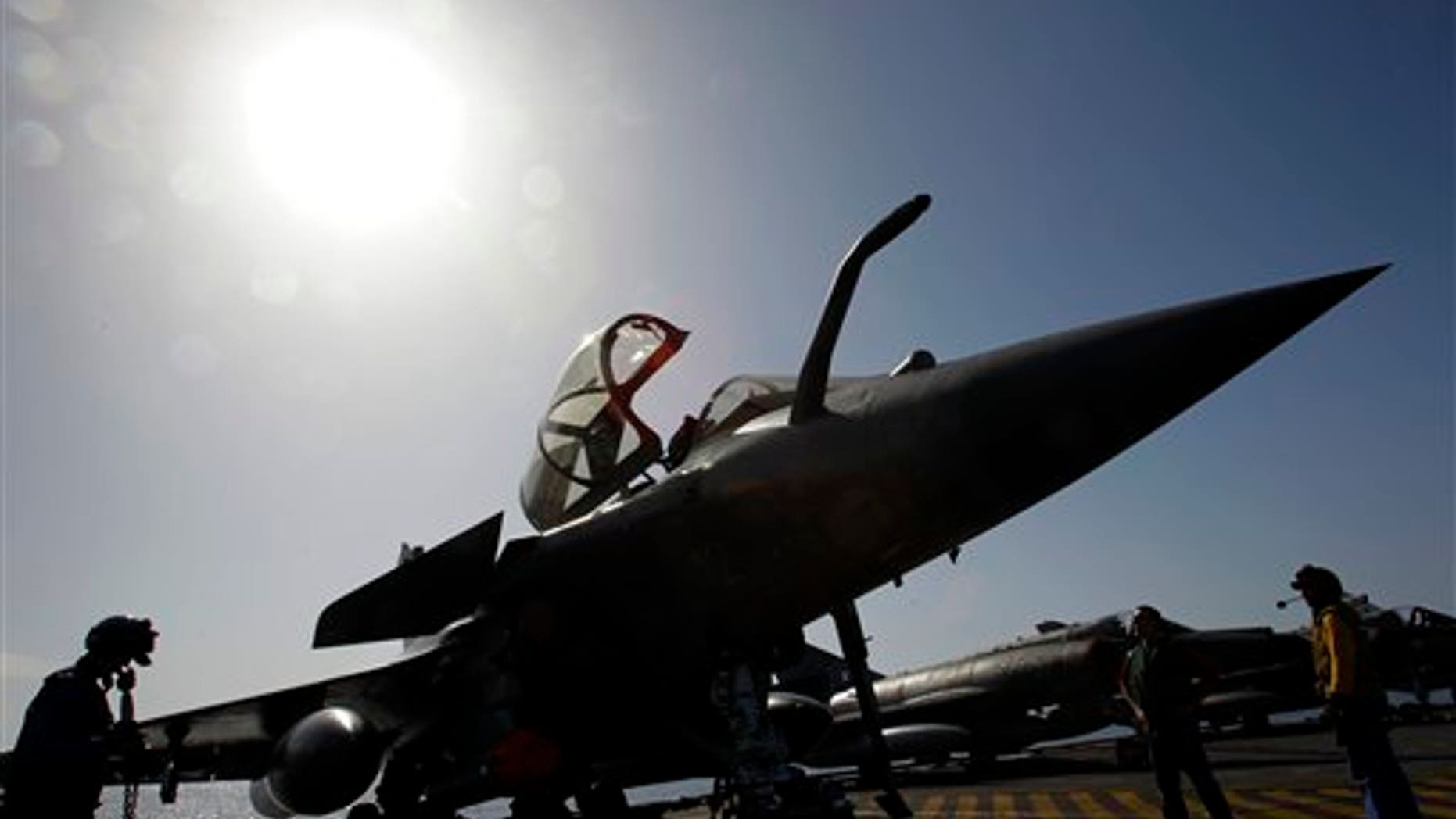 April 13: Mechanics works on a Rafale fighter jet before a mission over Libya from France's flagship Charles de Gaulle aircraft carrier, in the Gulf of Sirte, off the Libyan coast. The missions are aimed at enforcing the no-fly zone and suppressing any attacks by Gadhafi's forces against civilians and rebels in eastern Libya. (AP)