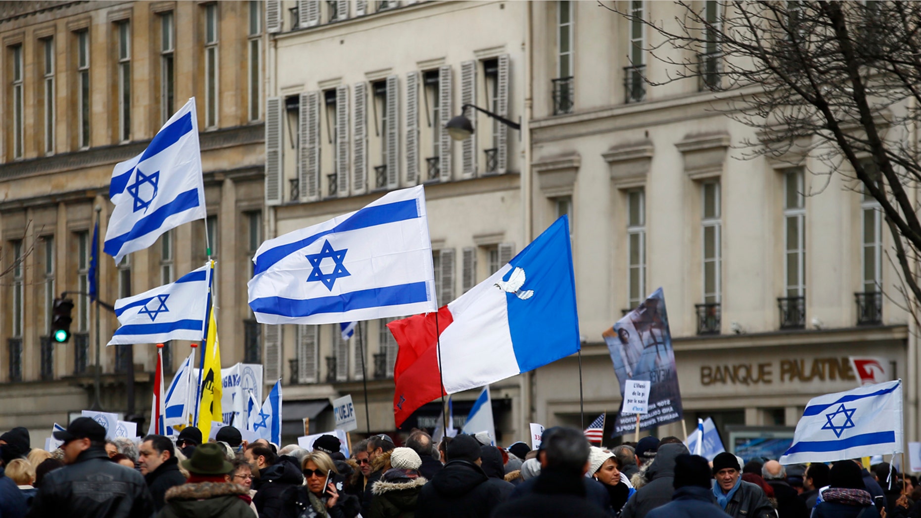 Pro-Israel demonstrators hold Isreali and France flags during a gathering in front of Israel embassy in Paris, France, Sunday, Jan. 15, 2017.