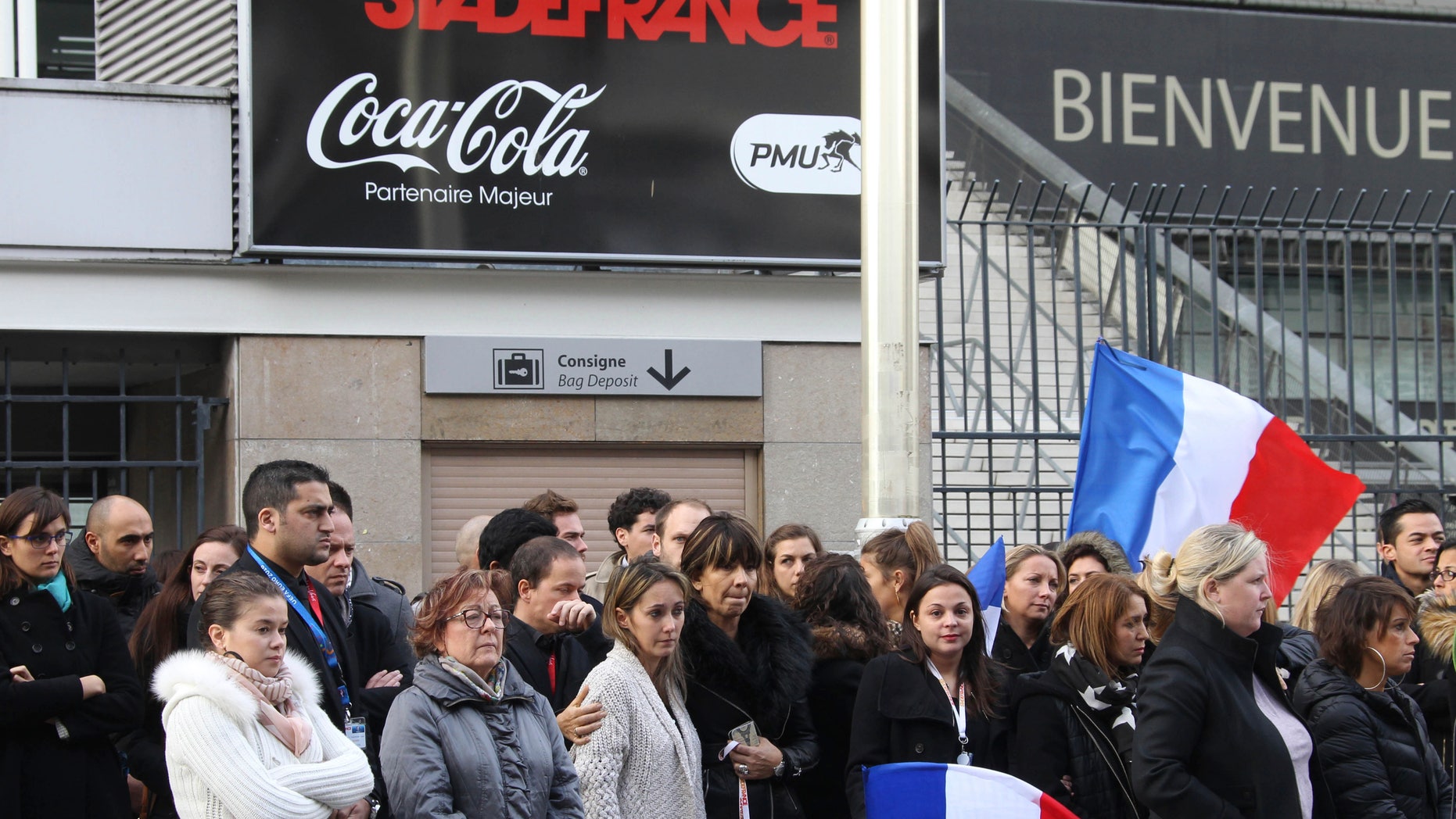 People stand for a minute of silence near the Stade de France stadium in Saint Denis, outside Paris.