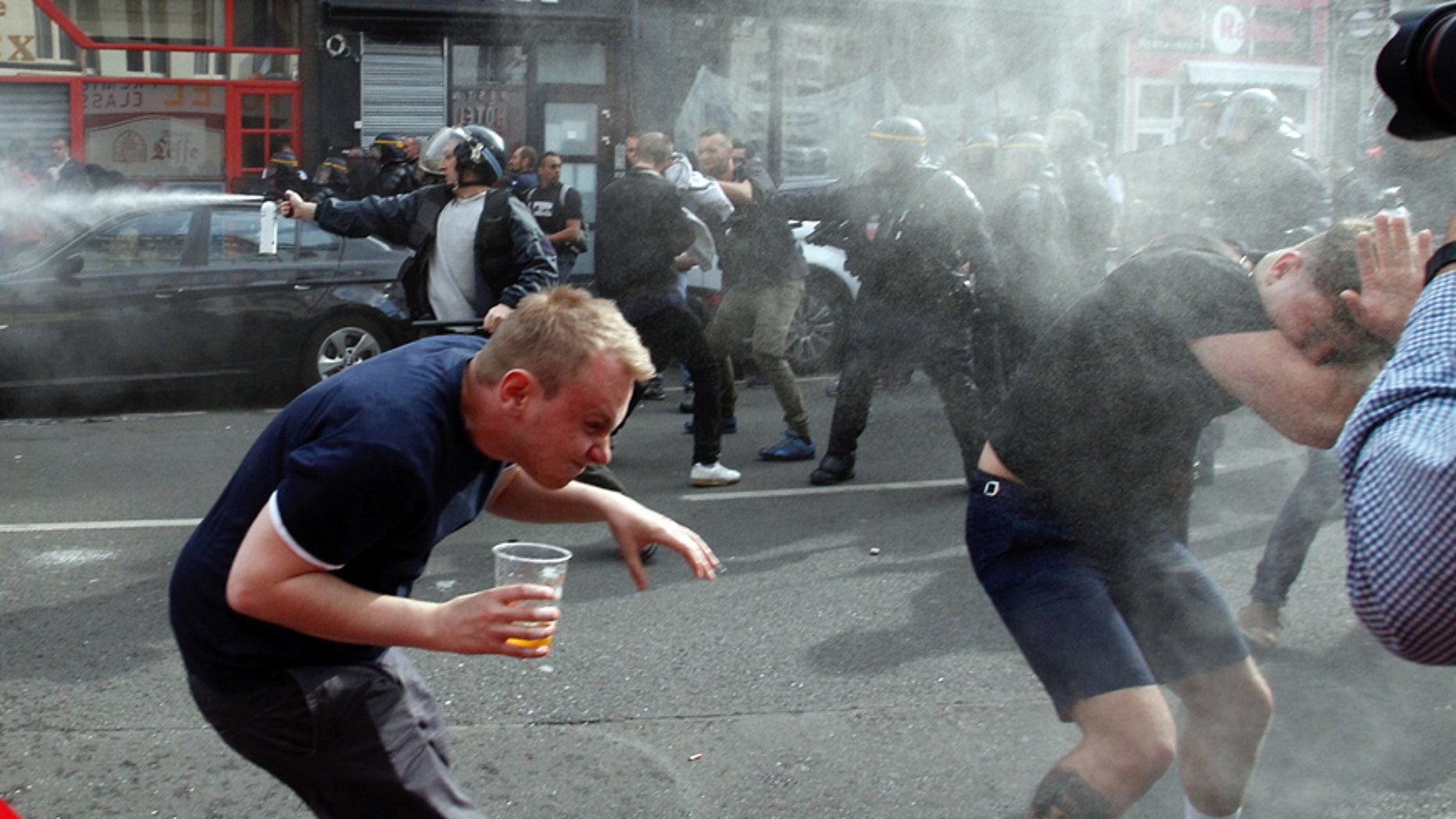 June 15, 2016: English fans run after getting sprayed with pepper spray by French police during scuffles in downtown Lille, northern France.