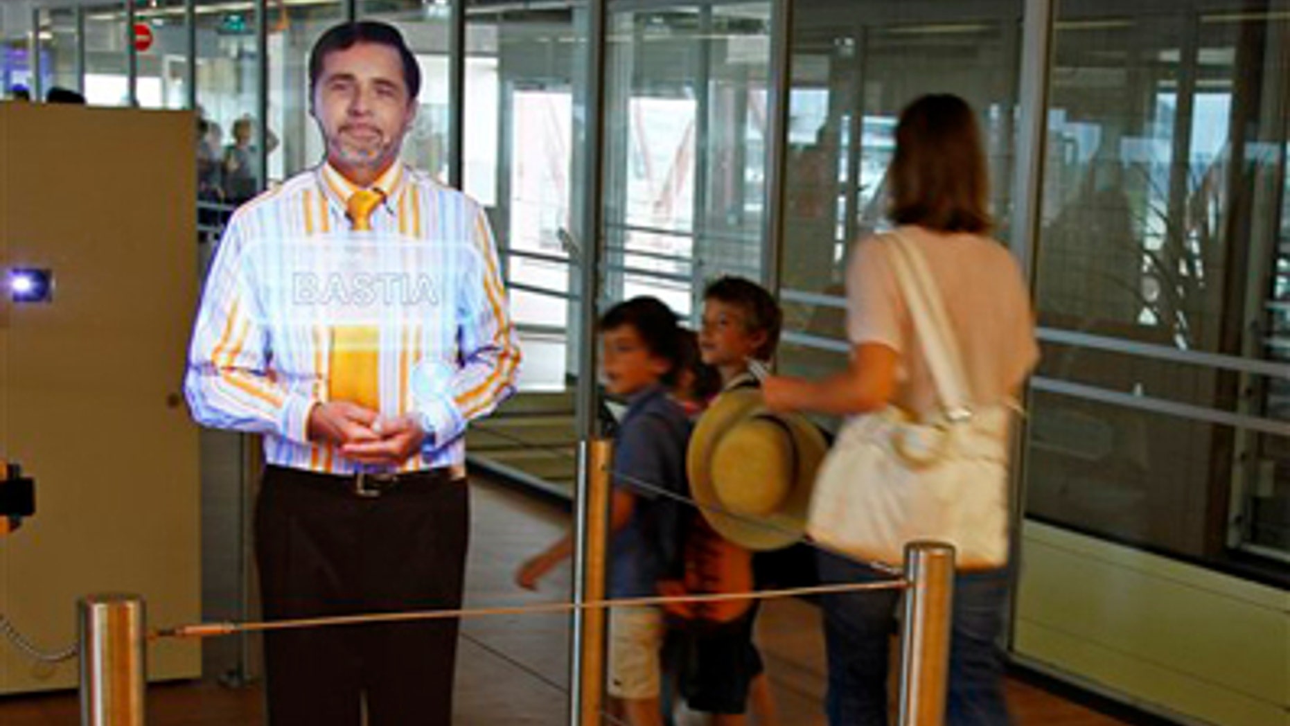 Aug. 18: An airport experimenting "virtual" boarding agent, left, is displayed at Paris' Orly airport, on the southern outskirts of Paris. The pilot project began last month, and has so far been met with a mix of amusement and surprise by travellers, who frequently try to touch and speak with the strikingly life-like video images that greet them and direct them to their boarding gate.