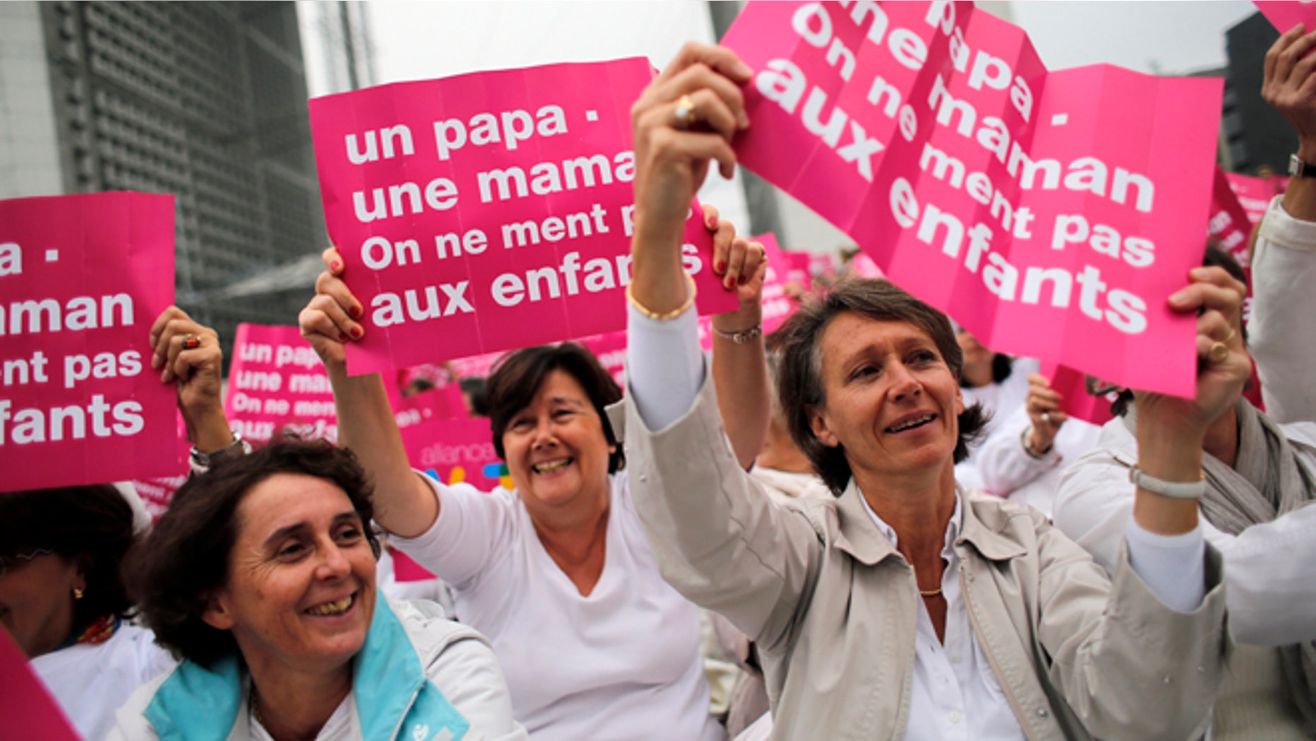 Oct. 23, 2012: In this file photo, anti-gay marriage and gay adoption rights activists hold posters reading: "Mother - Father. Don't lie to your children" demonstrate in Paris. A plan to legalize same-sex marriage and allow gay couples to adopt was a liberal cornerstone of French President Francois Hollande's election manifesto earlier this year.