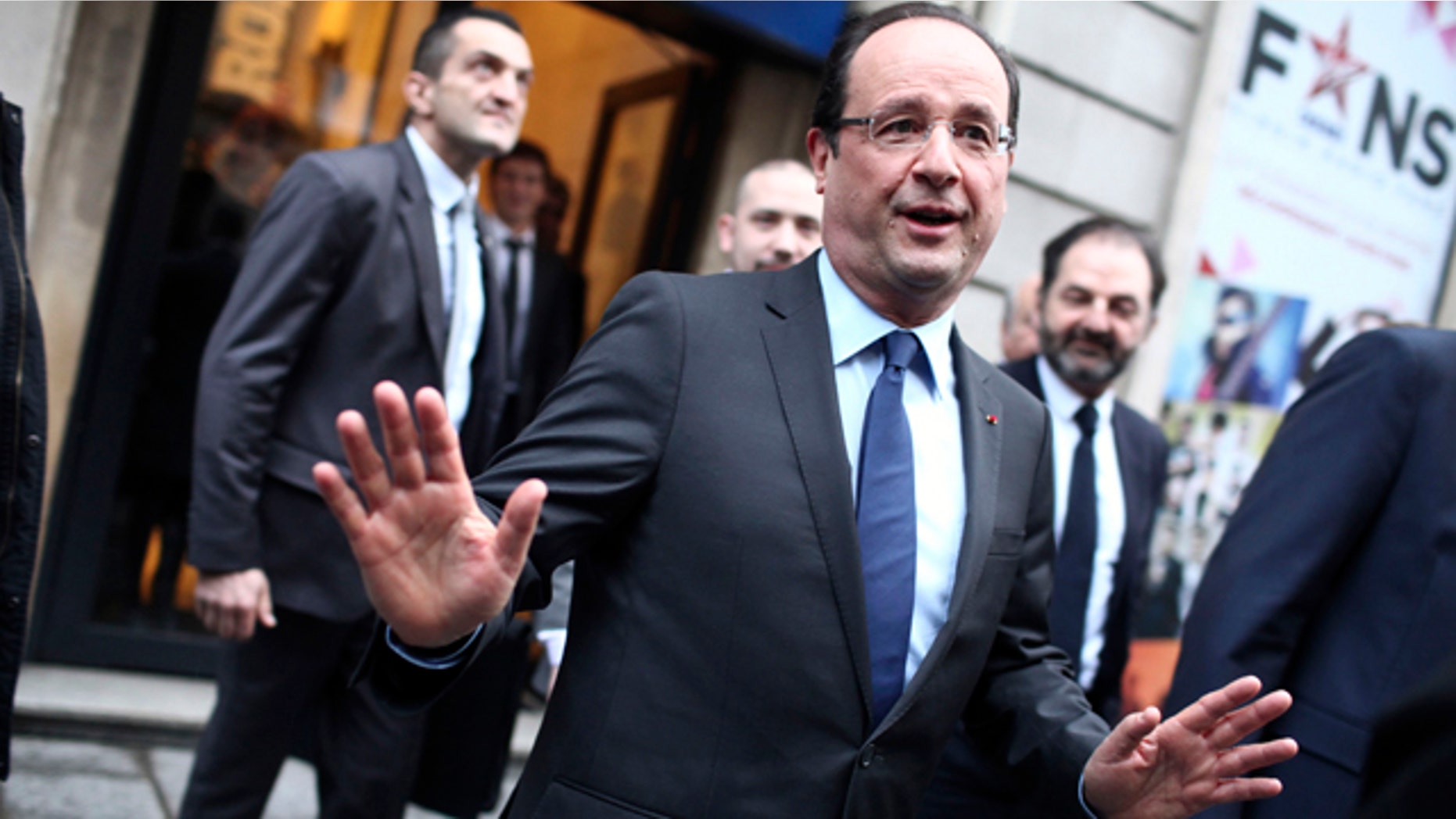 Dec. 21, 2012: France's President Francois Hollande, center, gestures as he leaves the Europe 1 radio station after an interview, in Paris.