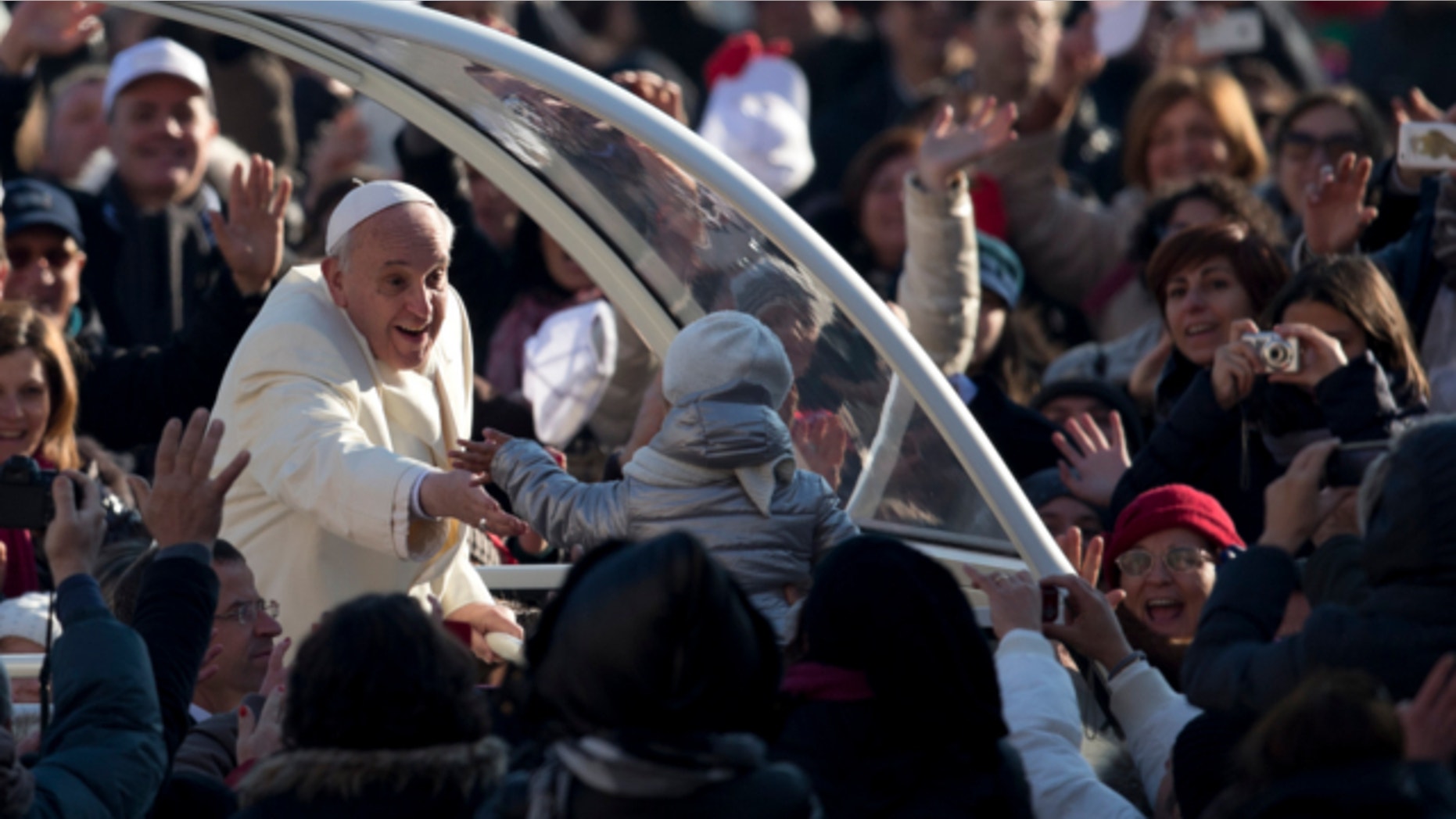 Dec. 11, 2013: Pope Francis is greeted by faithful as he arrives for his weekly general audience in St. Peter's Square at the Vatican.