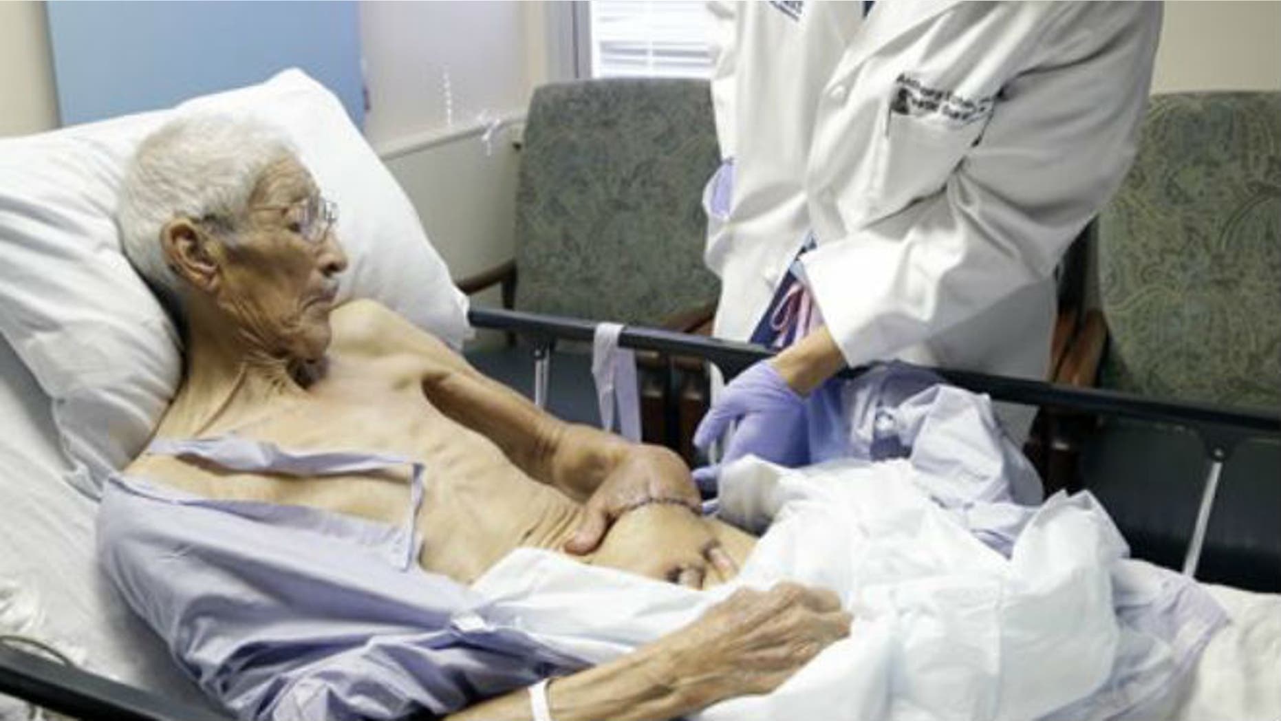Plastic surgeon Anthony Echo, right, examines Frank Reyes' hand before surgery at Houston Methodist Hospital in Houston on Thursday, Aug. 27, 2015. (AP Photo/Pat Sullivan)