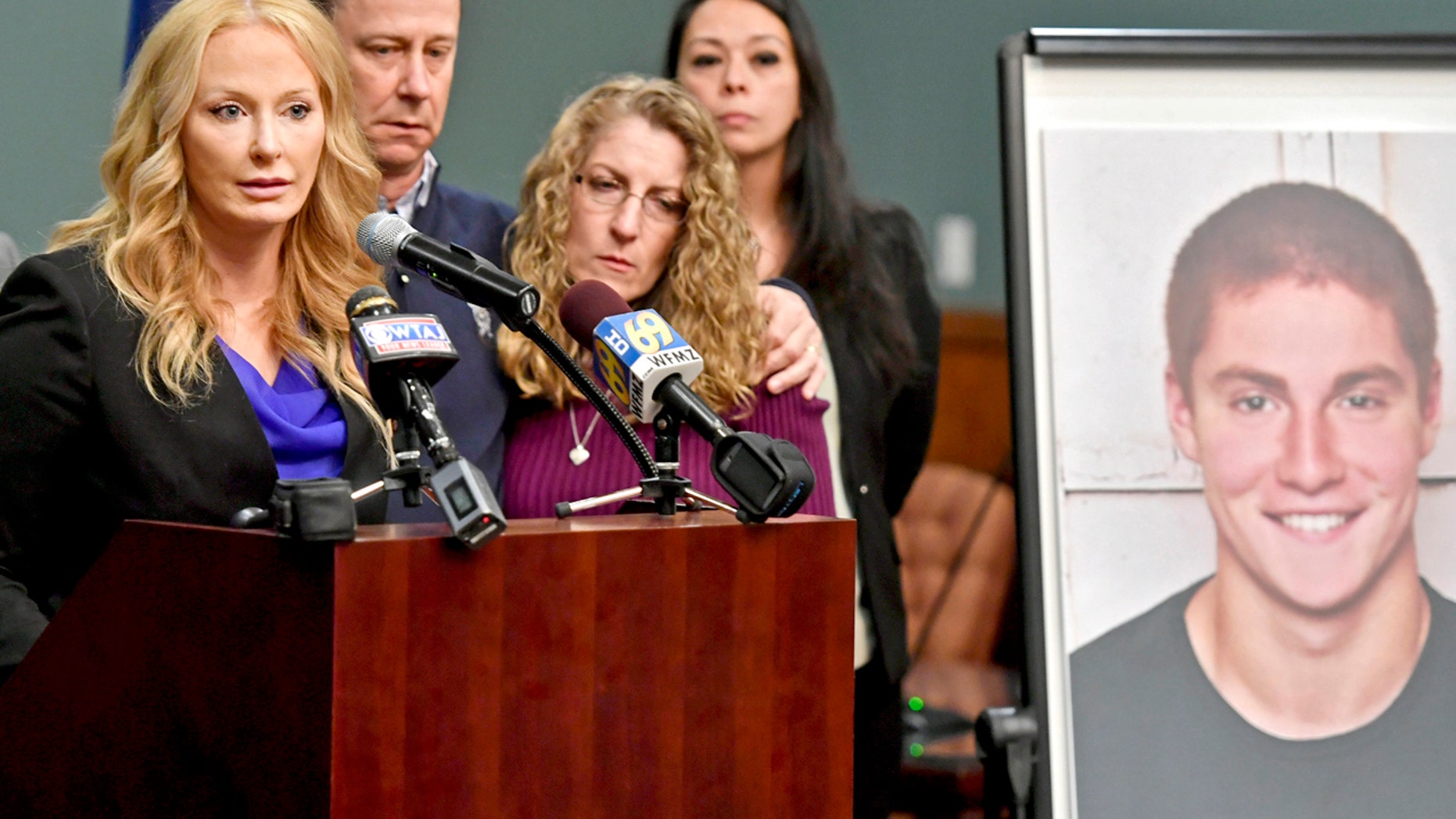 In this May 5, 2017, file photo, Centre County, Pa., District Attorney Stacy Parks Miller, left, announces findings an investigation into the death of Penn State University fraternity pledge Tim Piazza, seen in photo at right, as his parents, Jim and Evelyn Piazza, second and third from left, stand nearby during a news conference in Bellefonte, Pa.