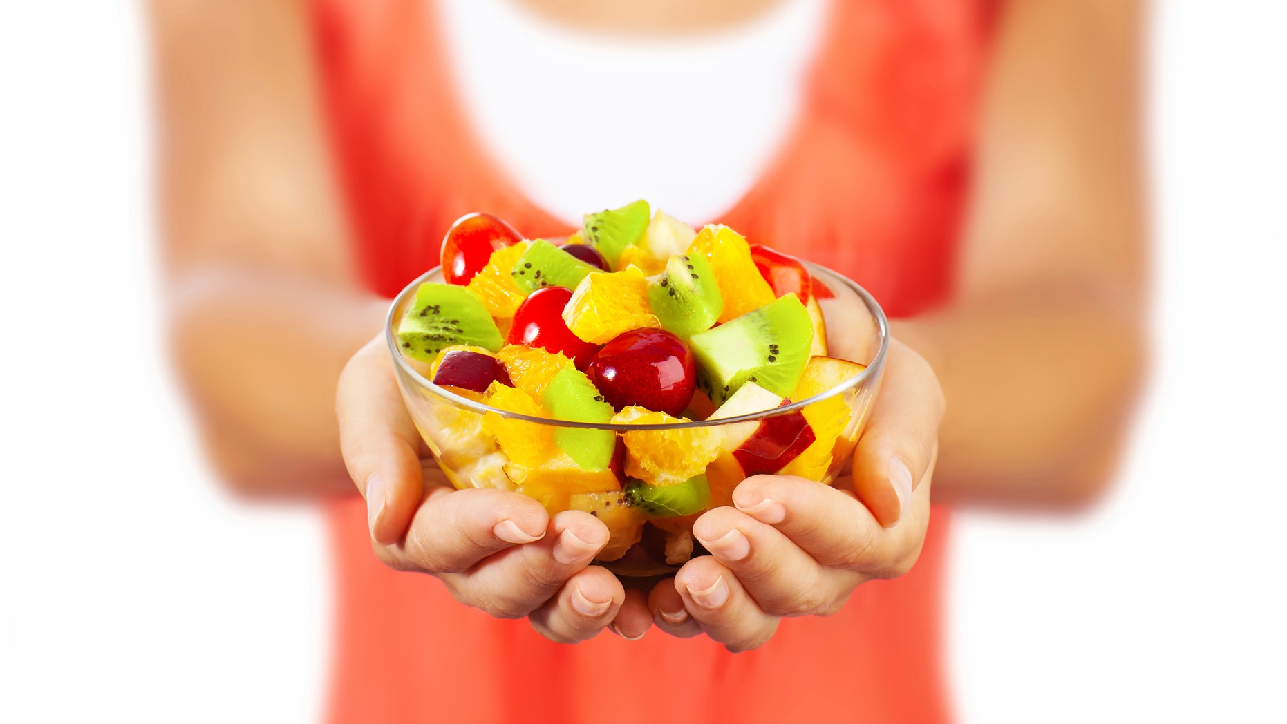 Healthy mix fruit salad, closeup on fresh summer dessert, woman holds lunch bowl, selective focus on female hands, eating girl shallow dof, body weight care, health and diet concept
