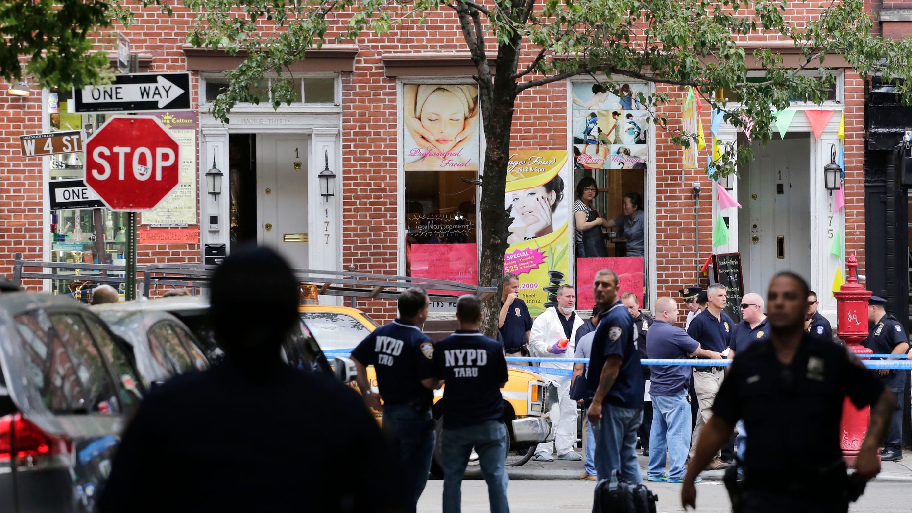 July 28, 2014: Police officers stand guard at the scene of a shooting in the Greenwich Village neighborhood in New York.